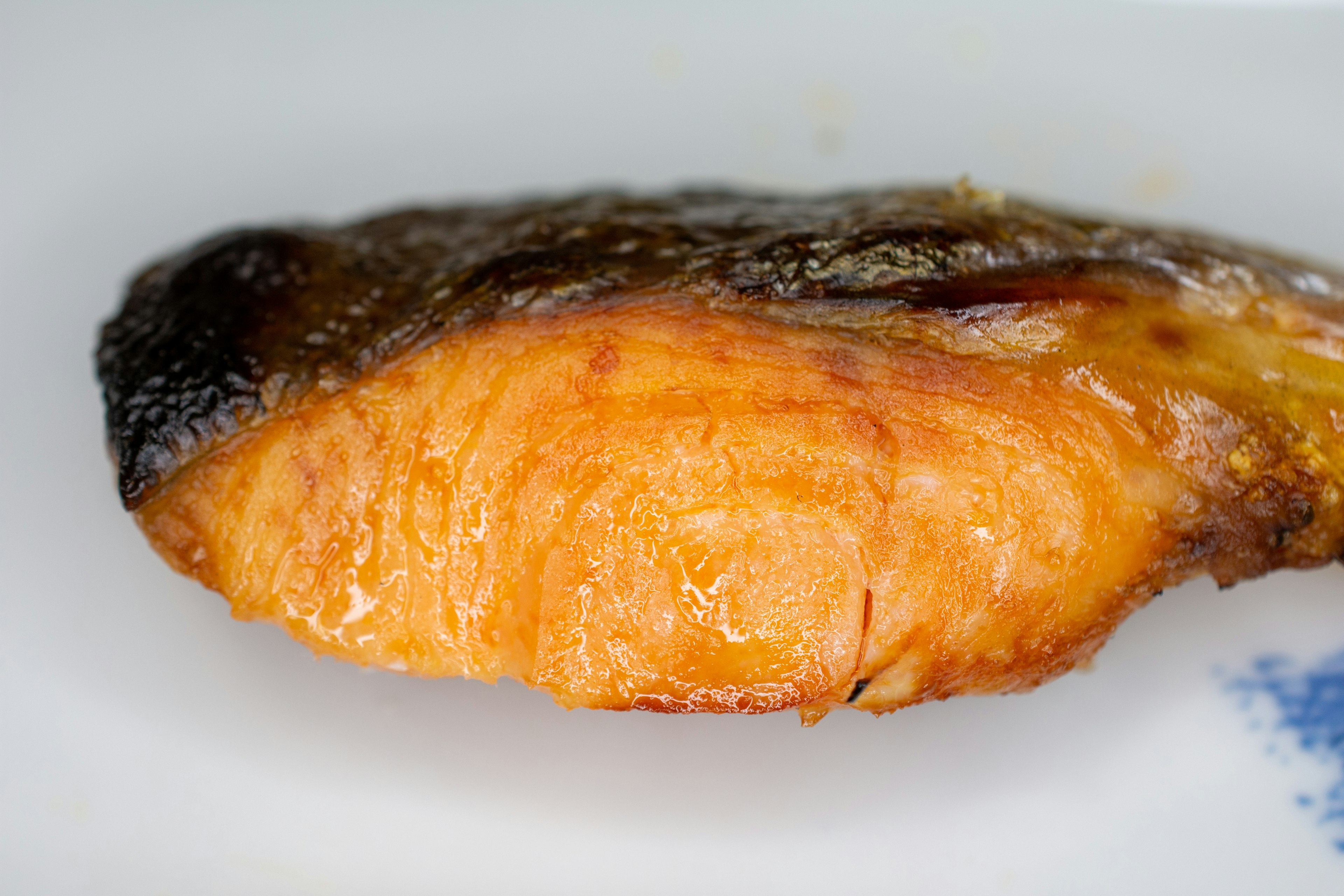 Primo piano di filetto di salmone grigliato con bordi bruciati e carne arancione