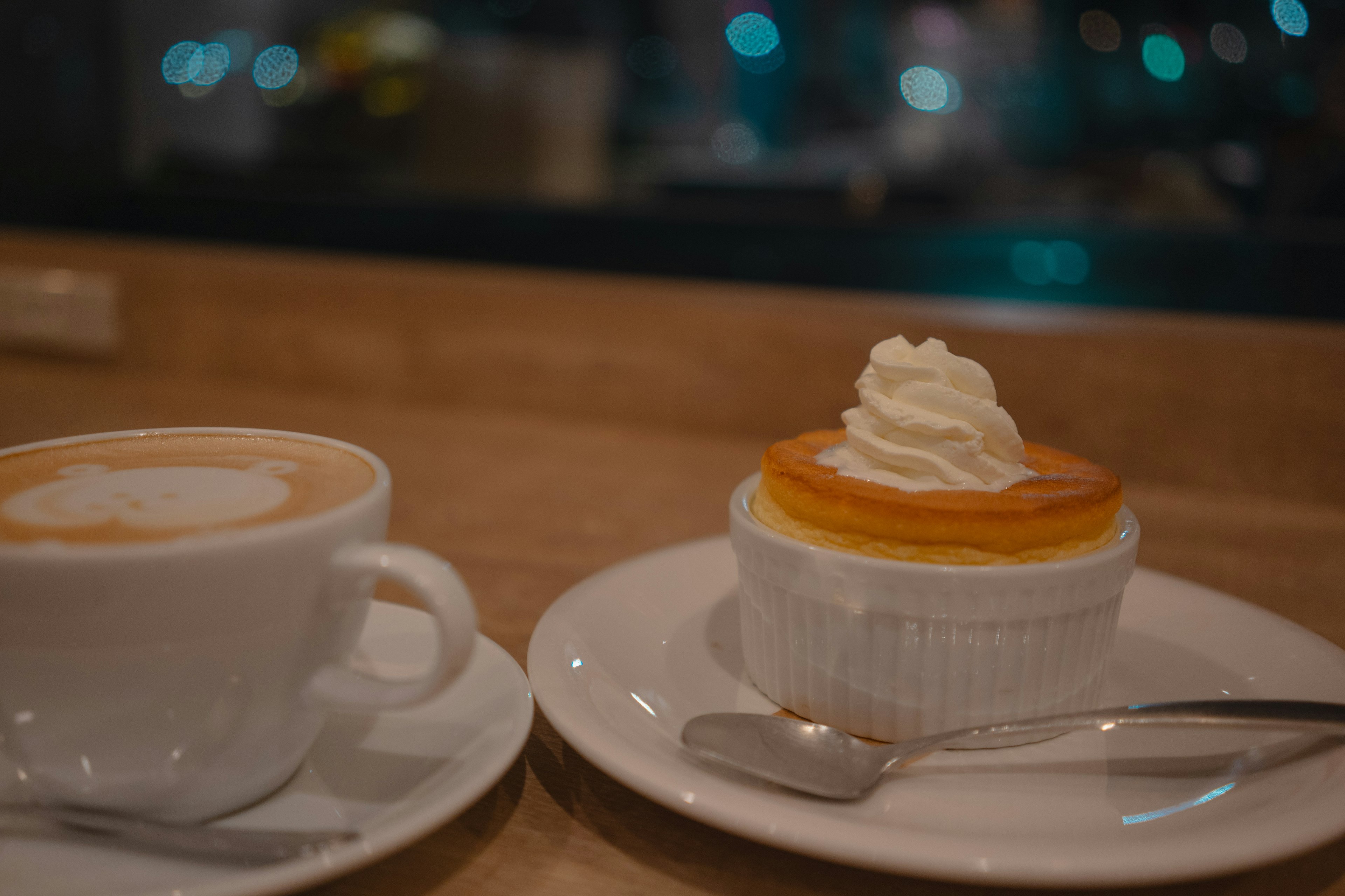 Tazza di caffè e dessert su un piatto vicino a una finestra di caffè