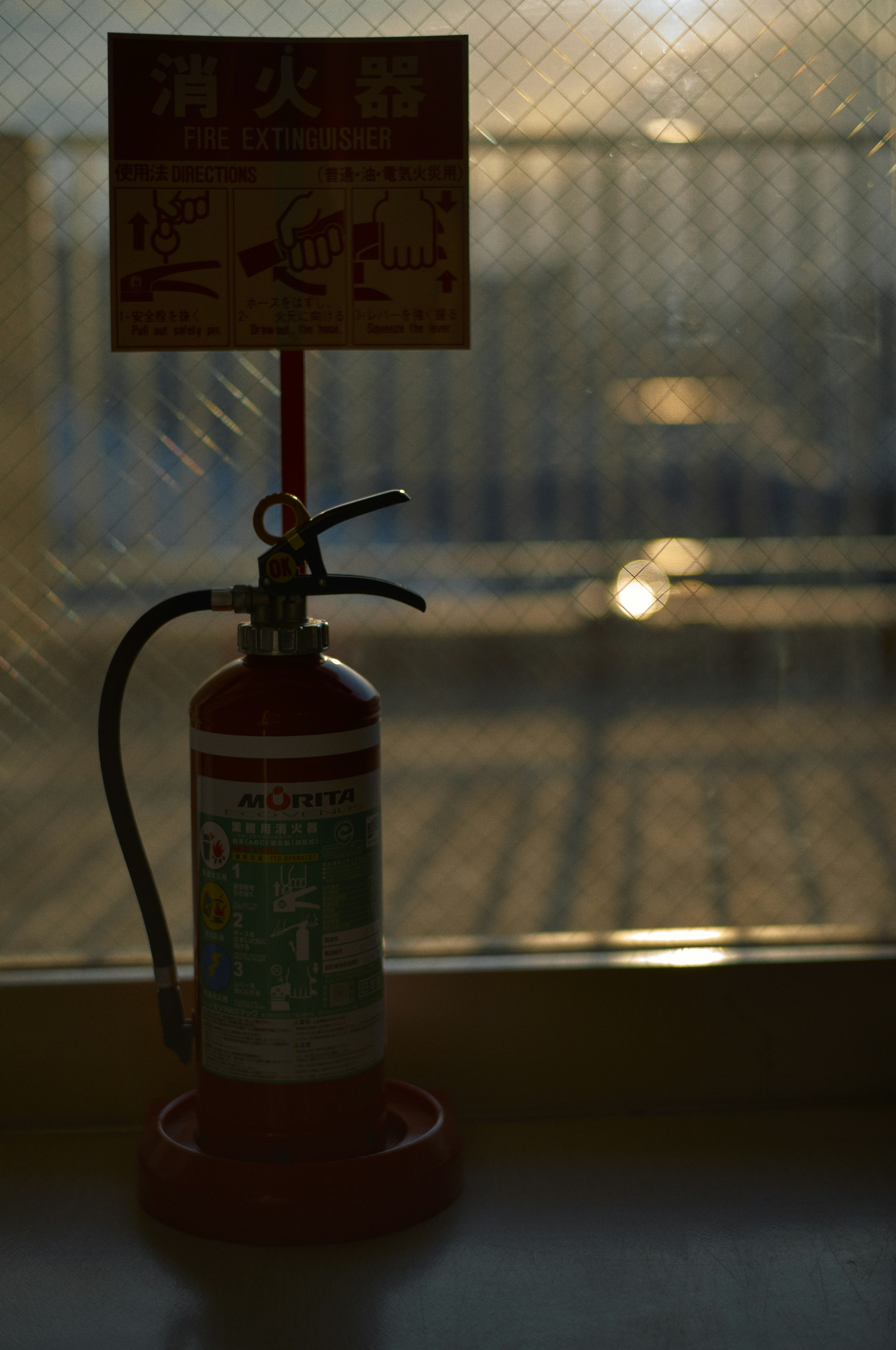 Silhouette of a fire extinguisher with an instructional sign displaying usage guidelines