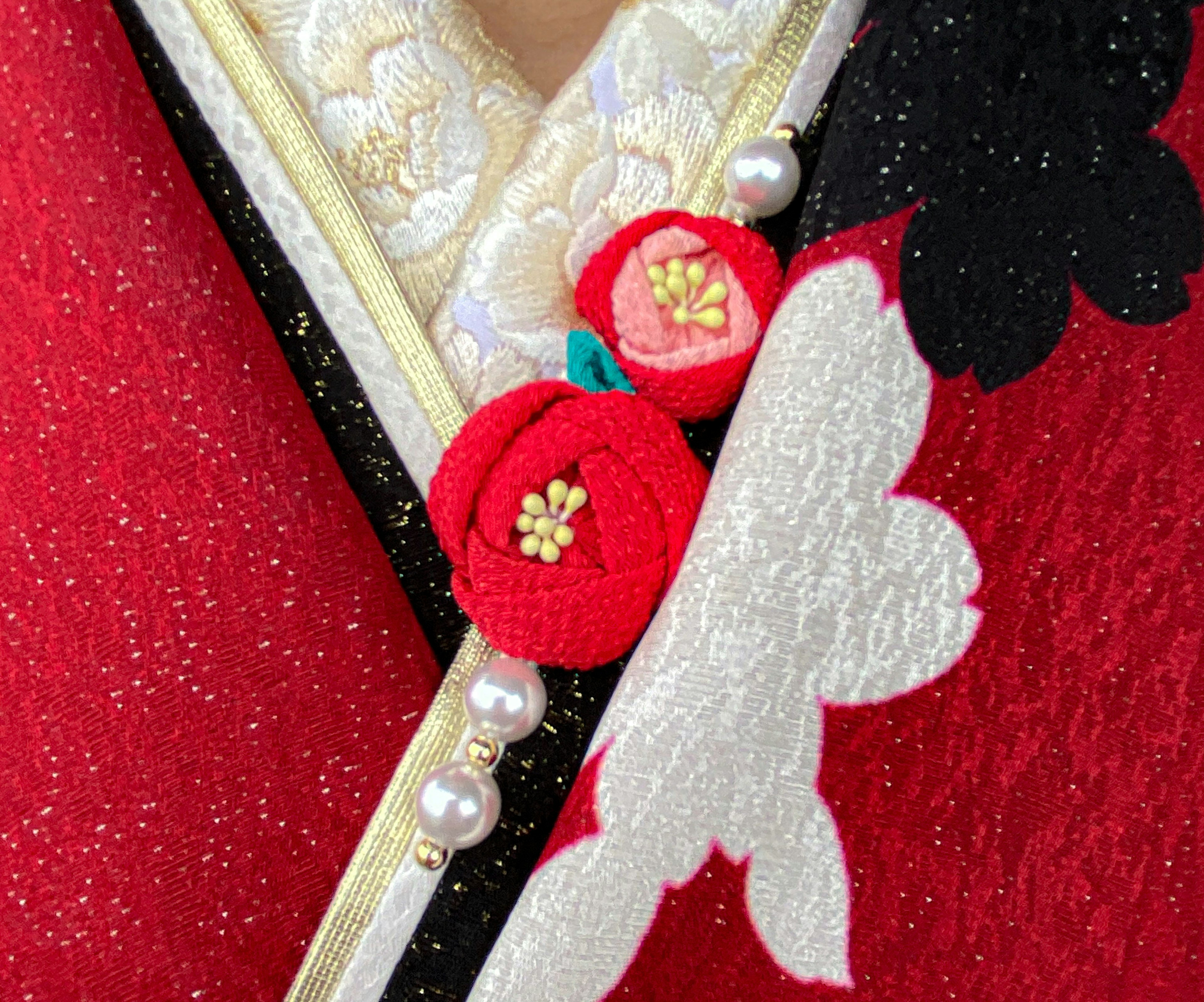 Un kimono rouge vif avec un motif floral blanc et des ornements floraux rouges