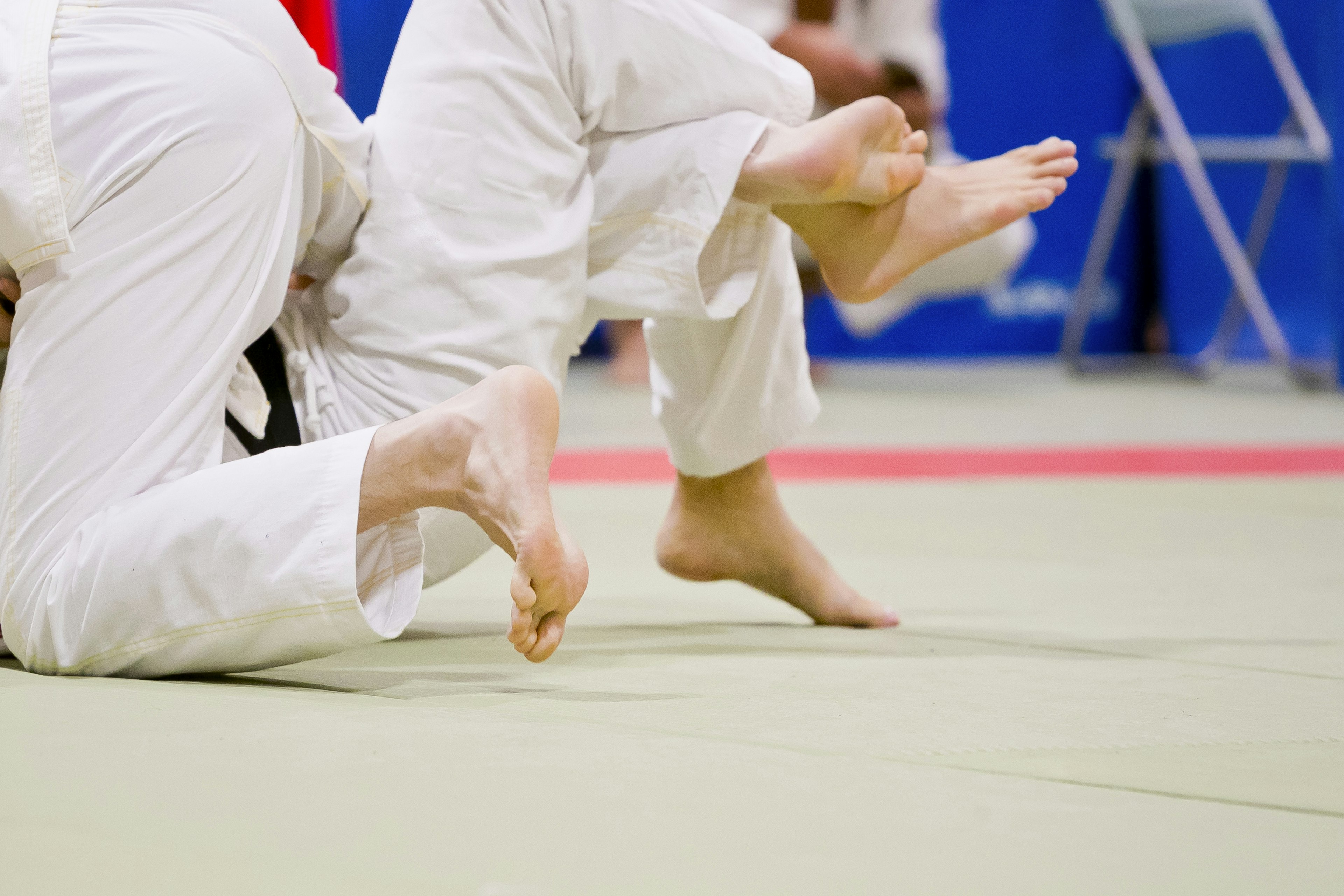 Primer plano de pies durante un combate de judo en tatami