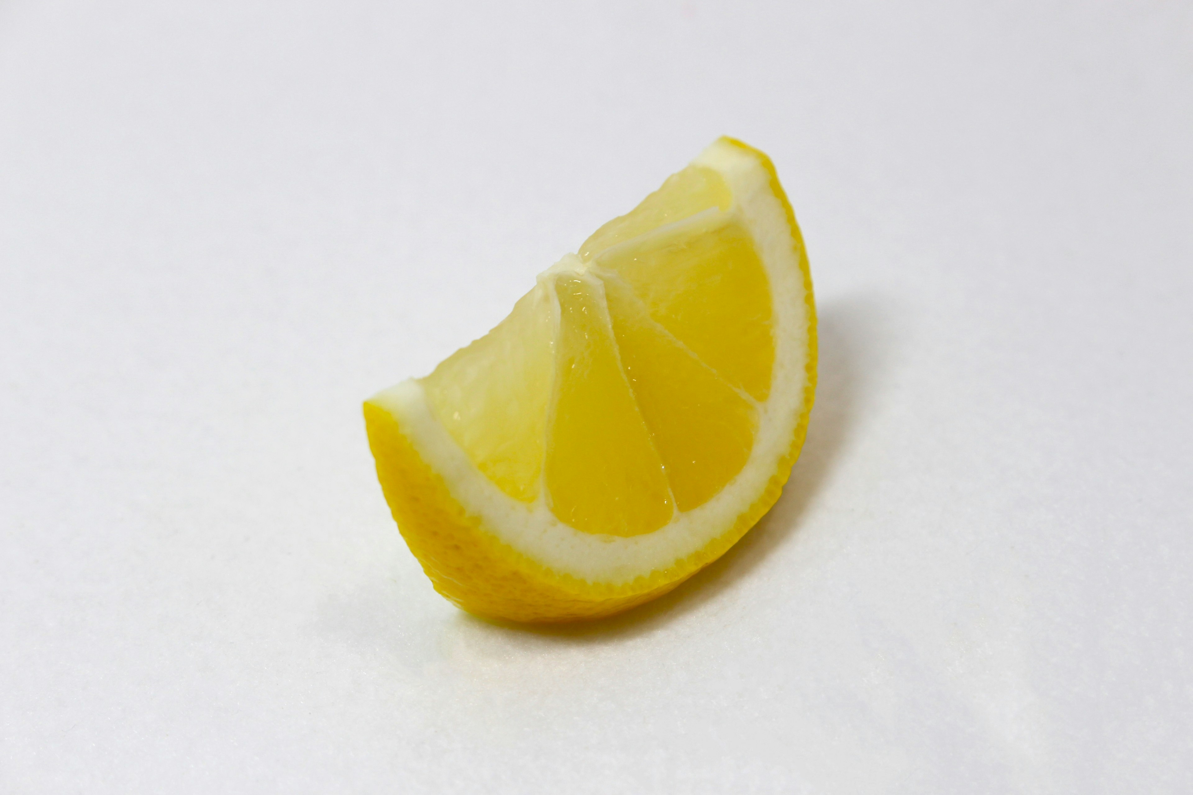 A slice of lemon placed on a white background