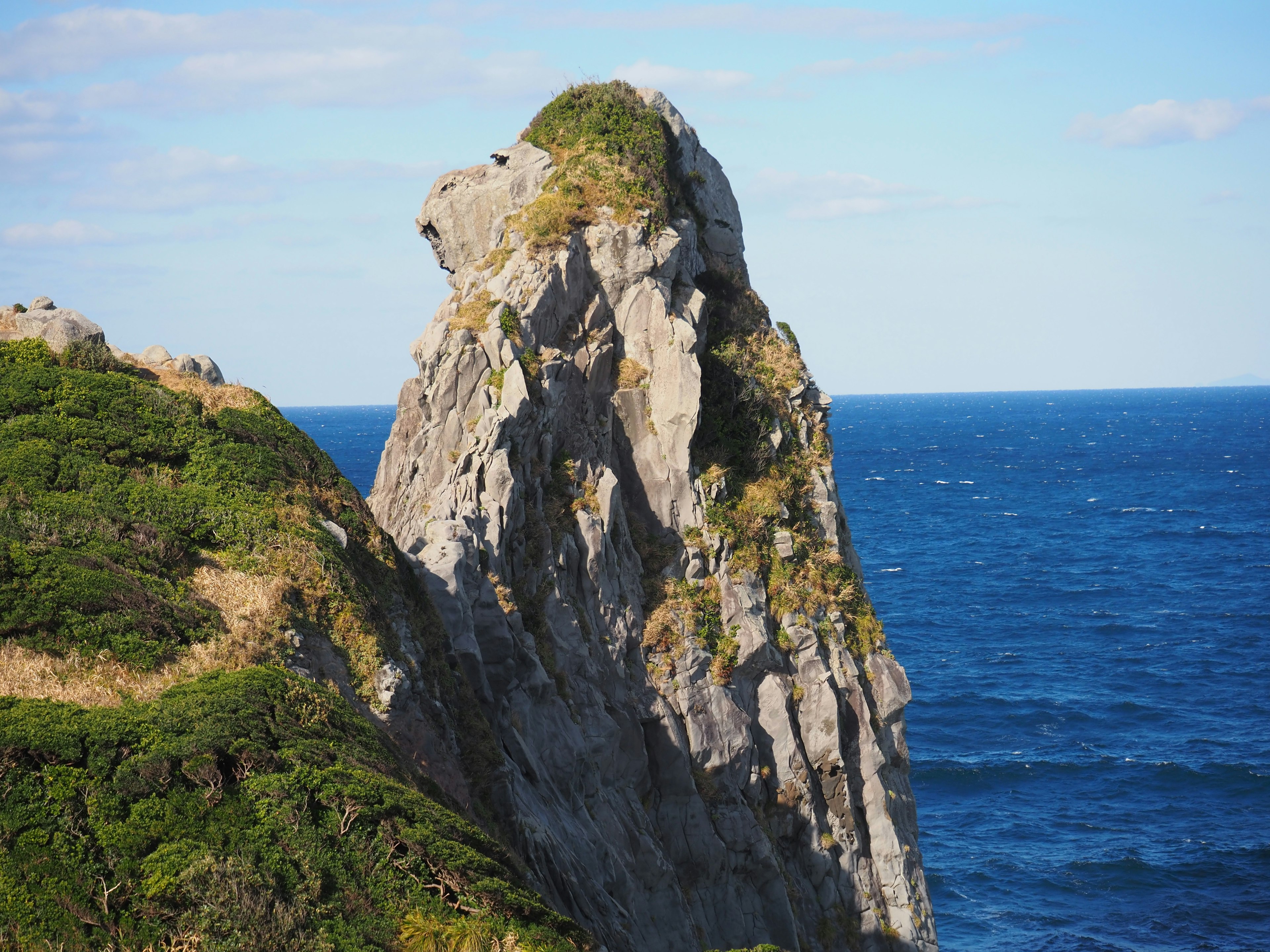 Einzigartige Felsformation, die über das Meer ragt, mit blauem Himmel