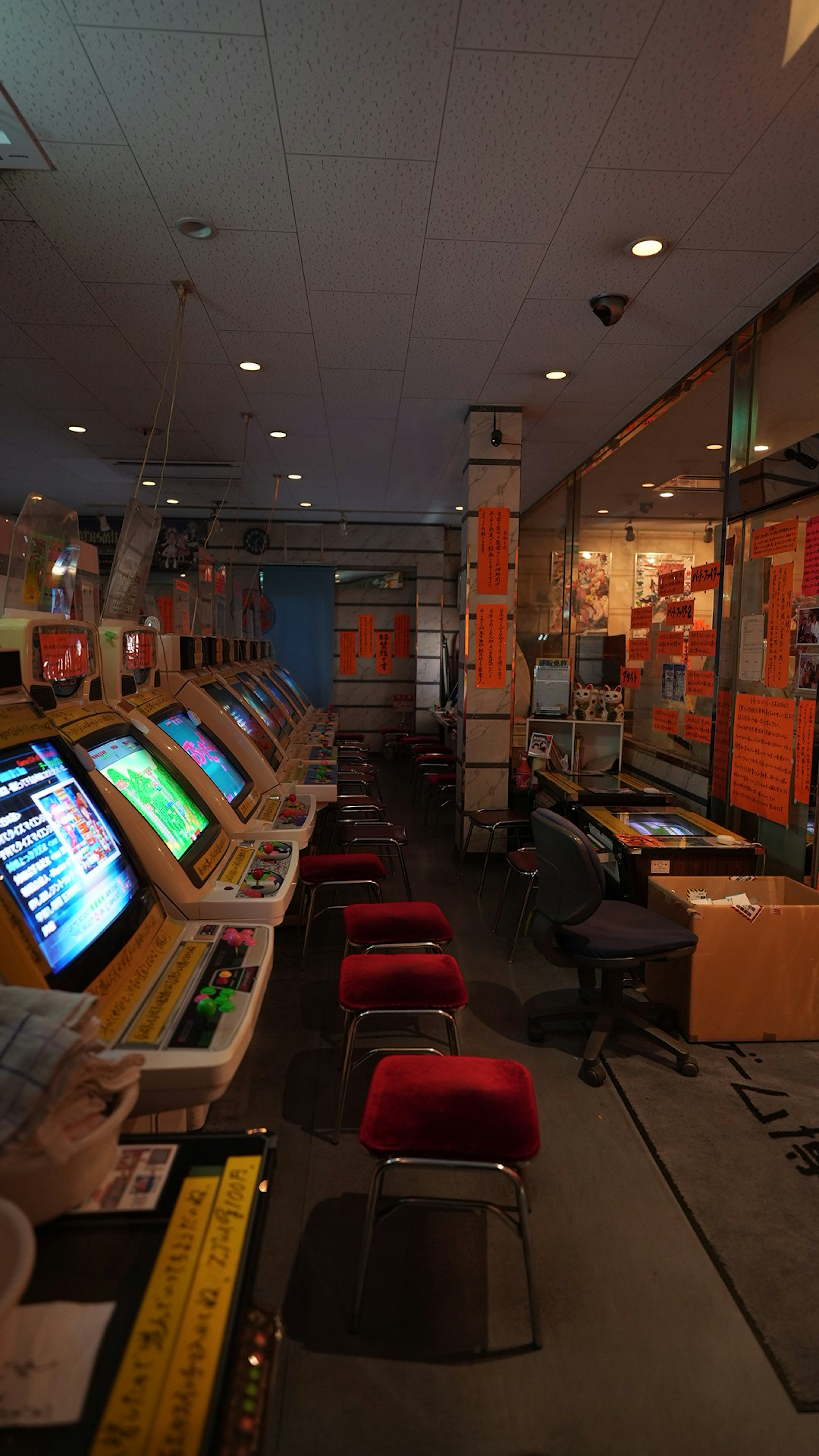 Intérieur d'un centre de jeux avec des écrans colorés et des chaises rouges alignées