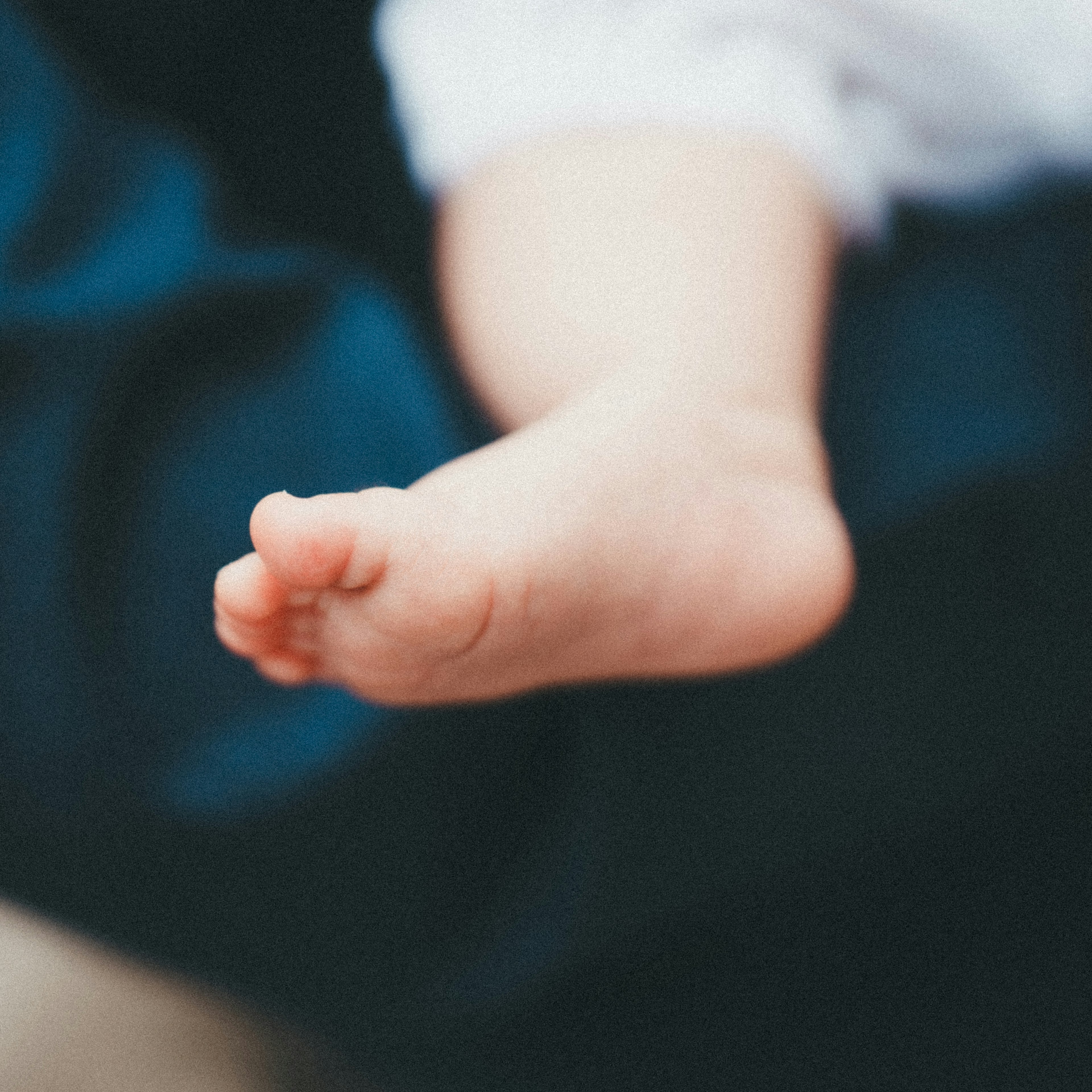 Primo piano del piede di un bambino su un tessuto blu