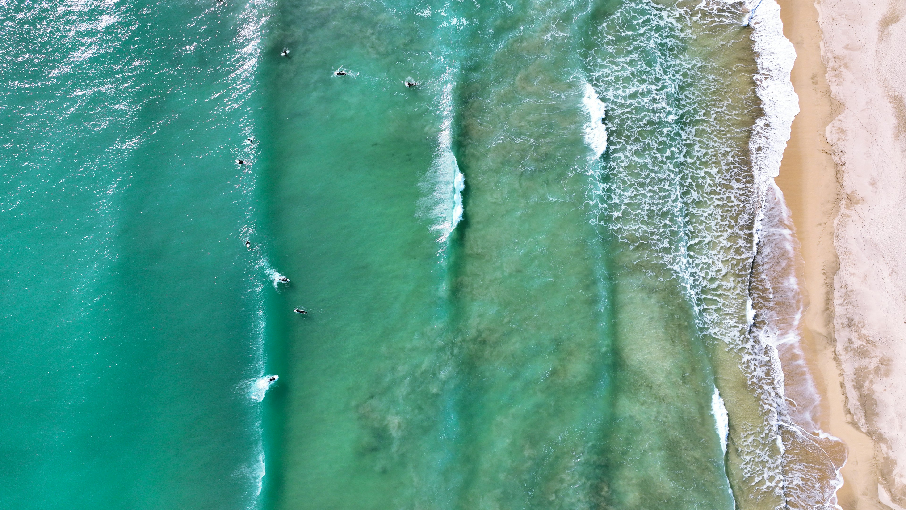 Aerial view of turquoise ocean waves and sandy beach