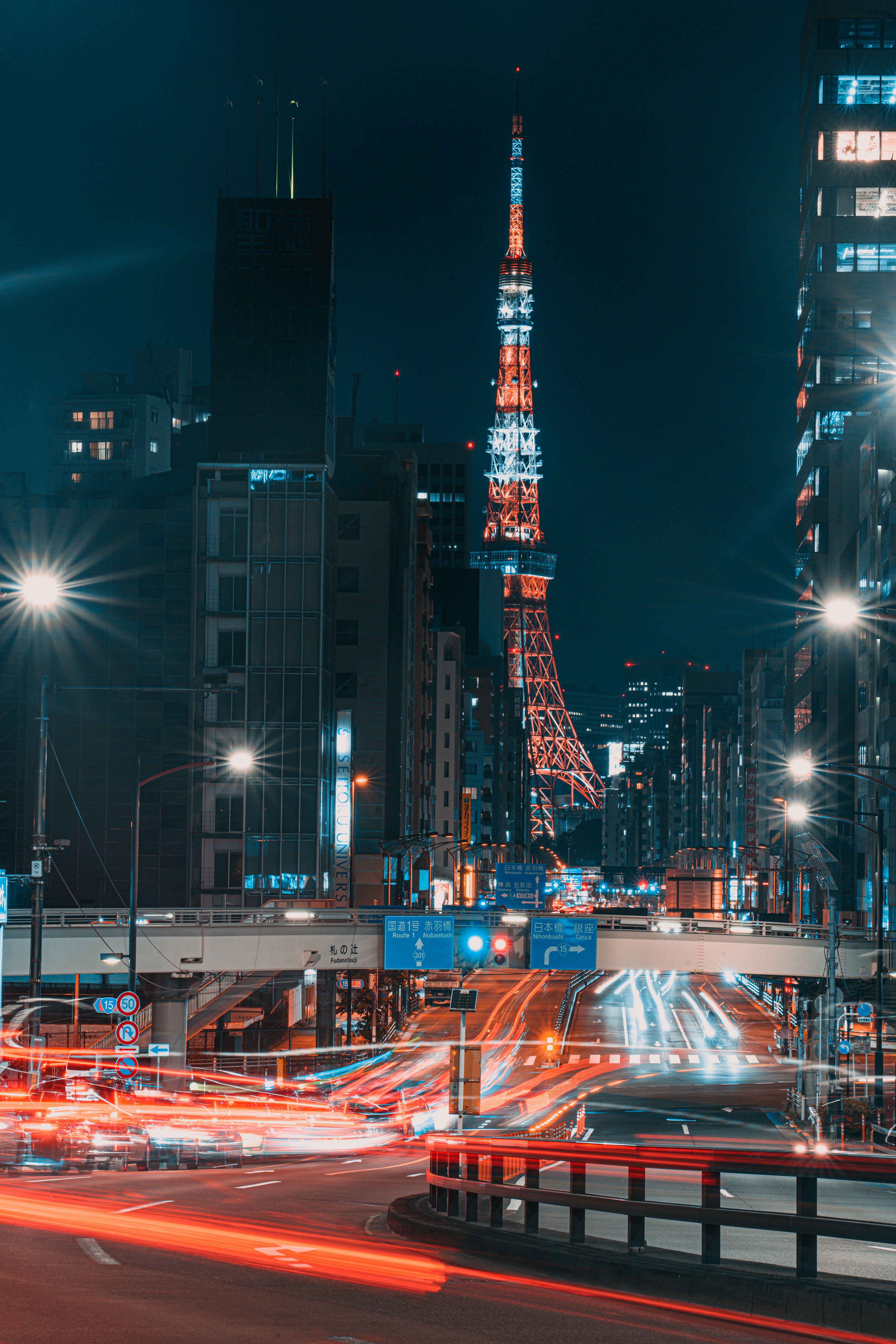 Torre di Tokyo illuminata di notte con luci di traffico in movimento