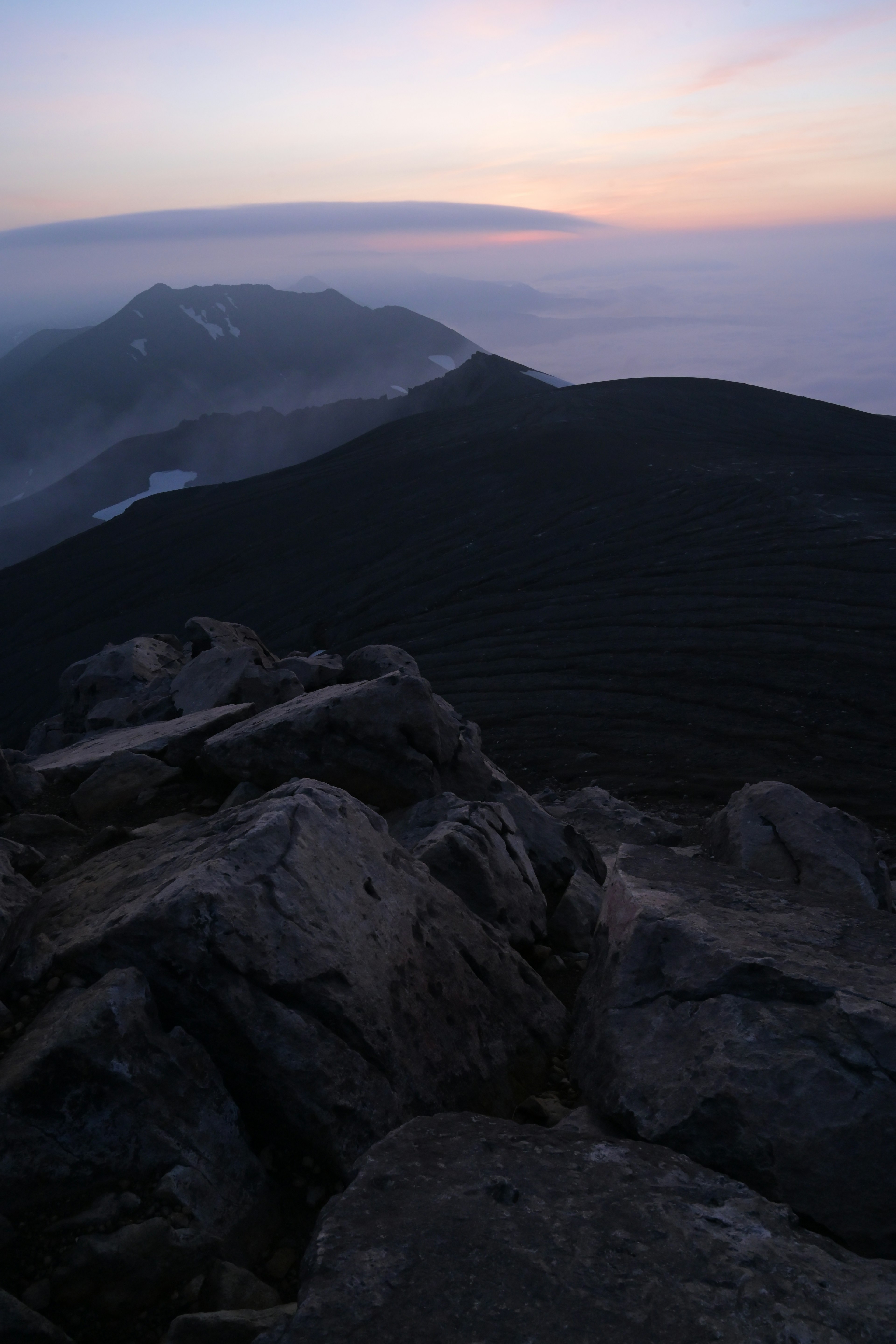 山頂的日落景觀藍色和橙色的天空及多雲的山脈