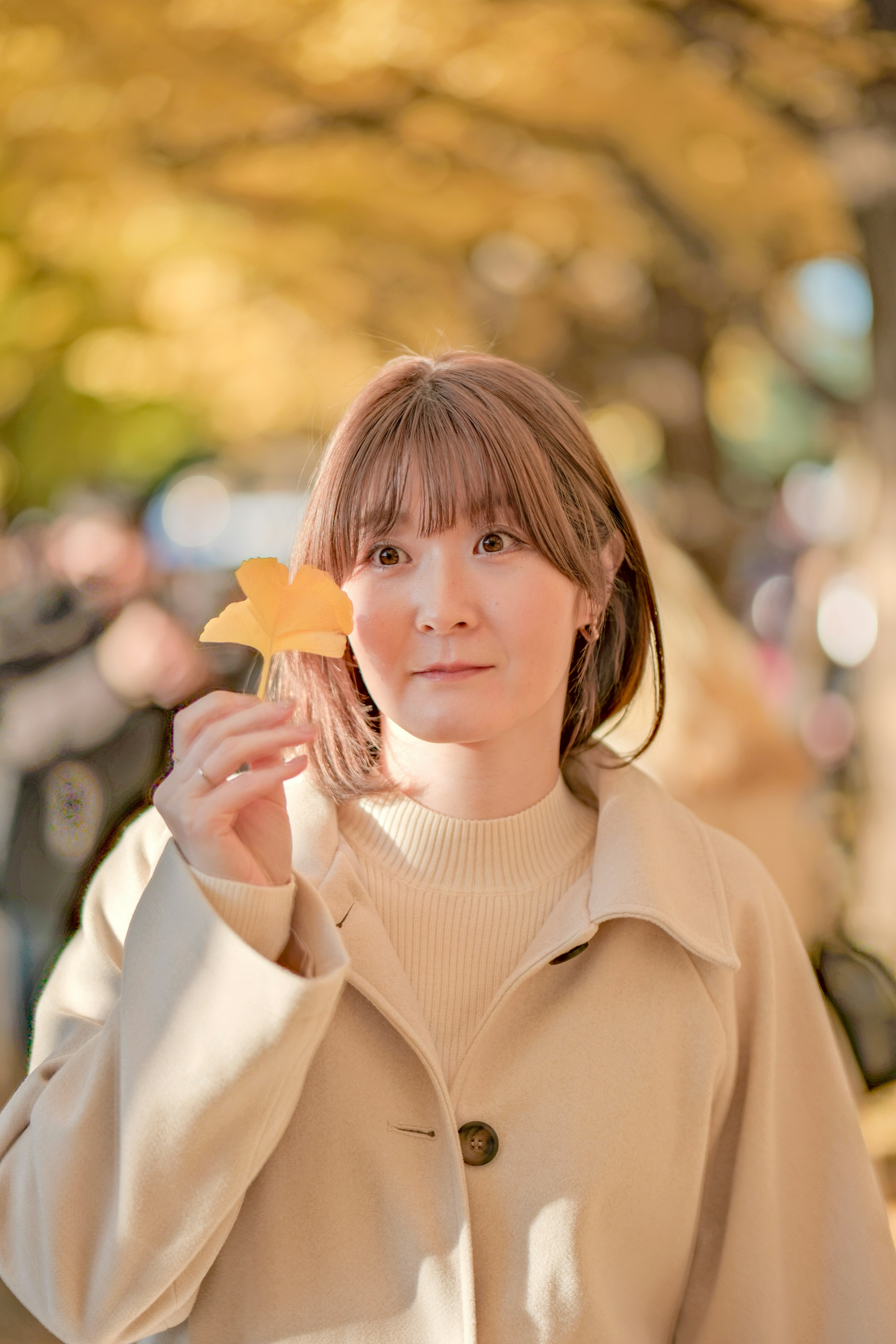 秋の公園で黄色い葉を持つ女性のポートレート