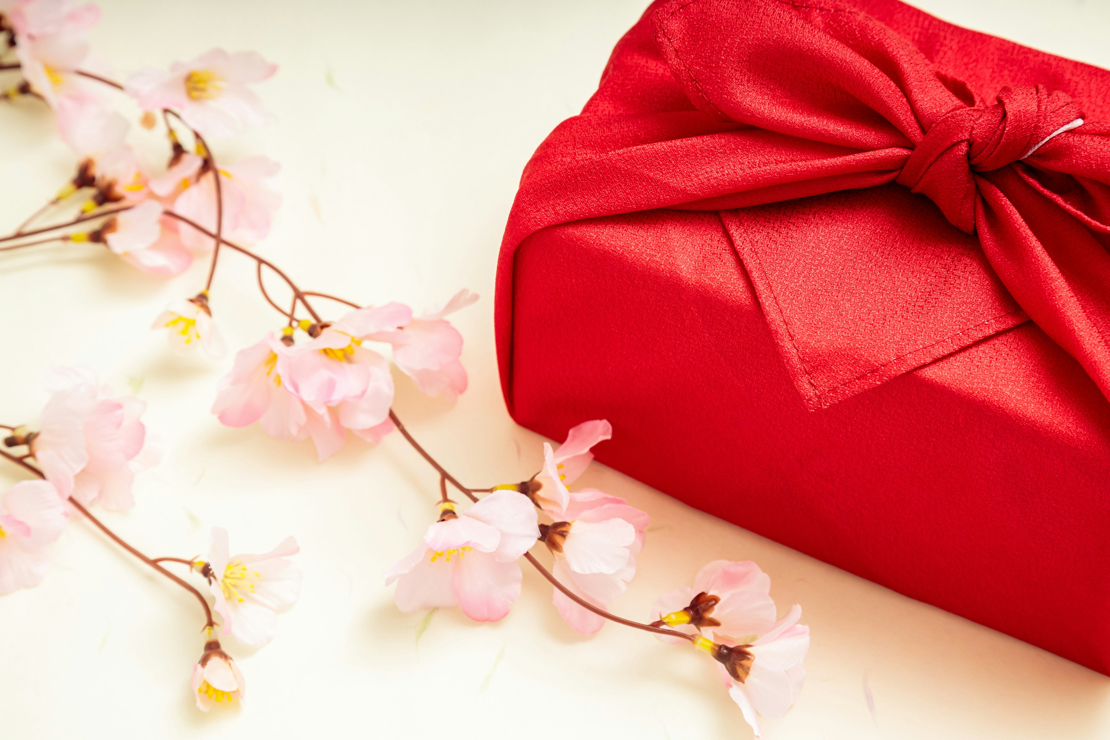 Red wrapped gift with cherry blossom flowers