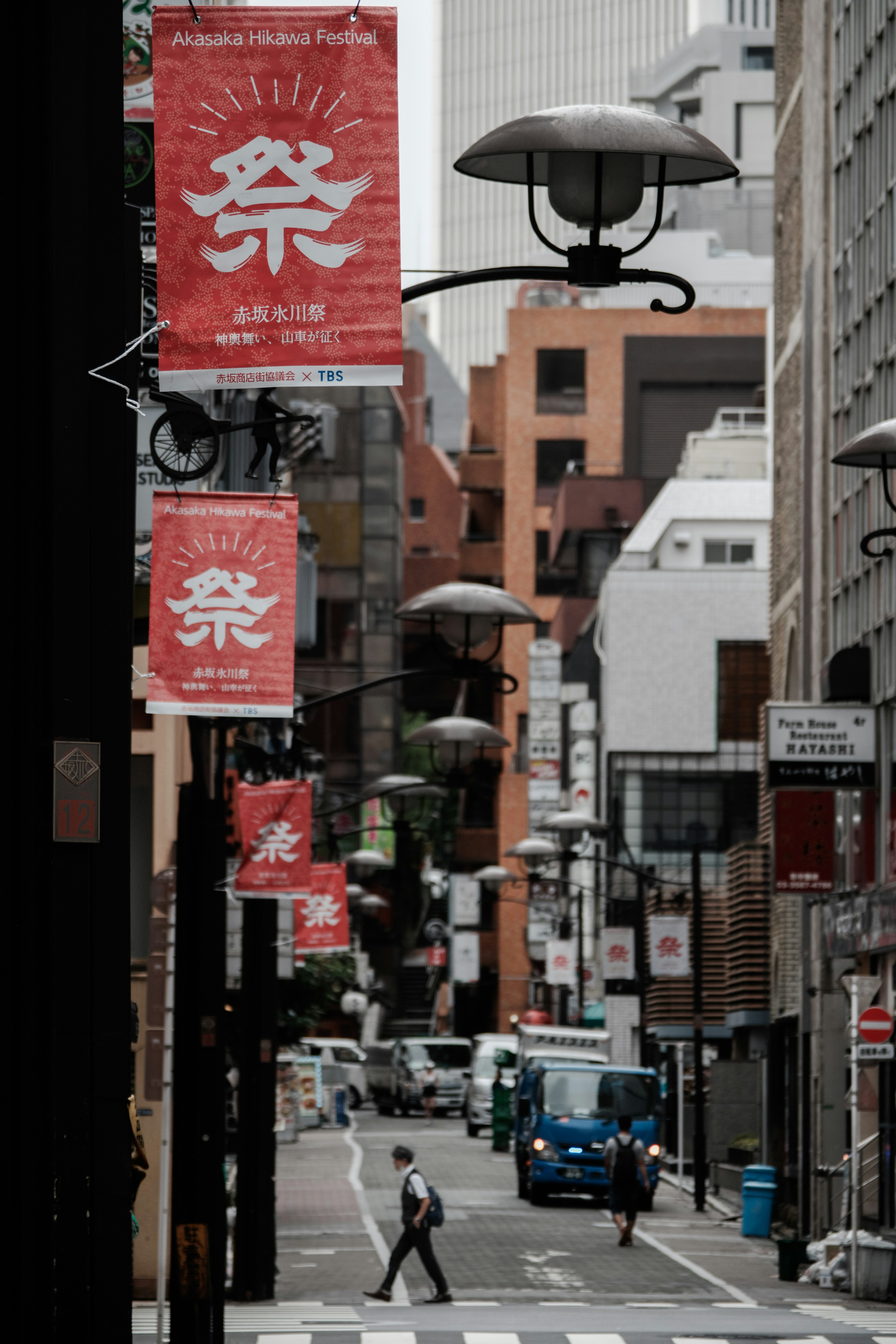 Calle de Tokio con llamativas pancartas rojas y faroles