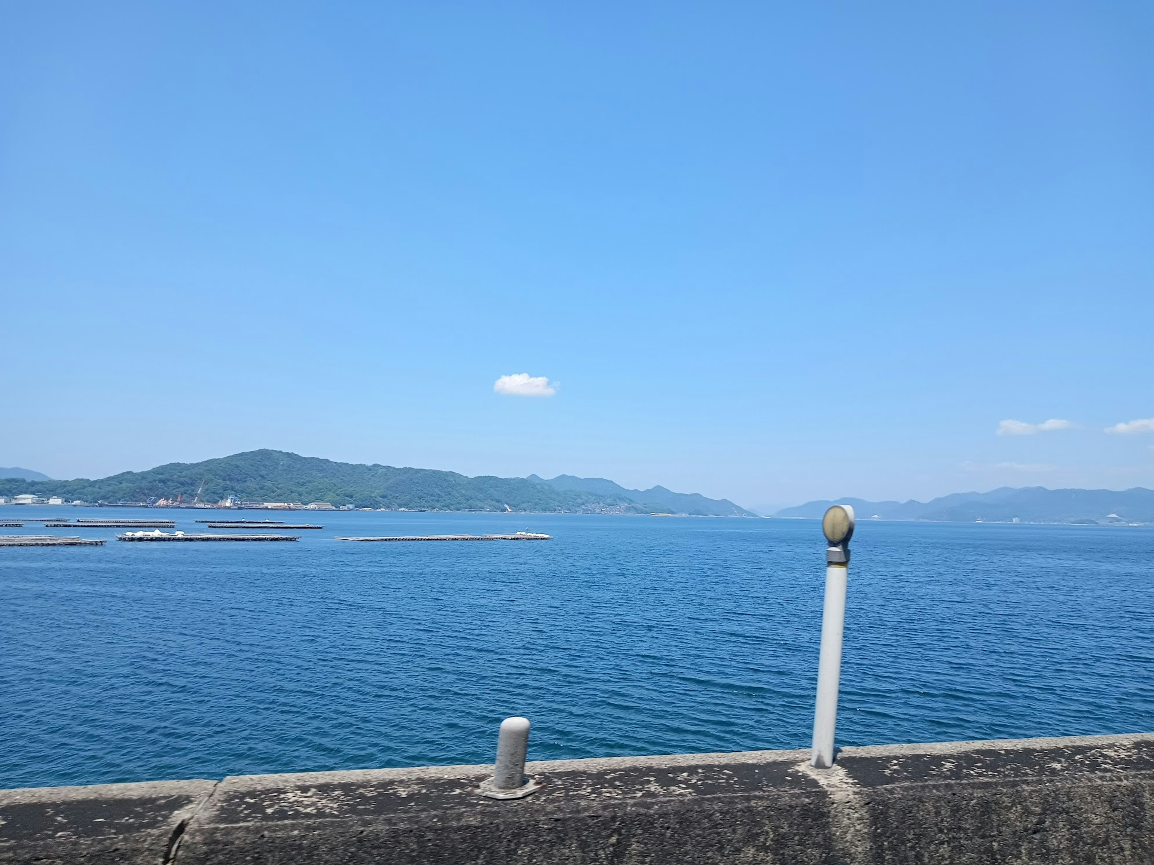 Beau paysage maritime avec océan bleu et ciel silhouettes de montagnes lointaines