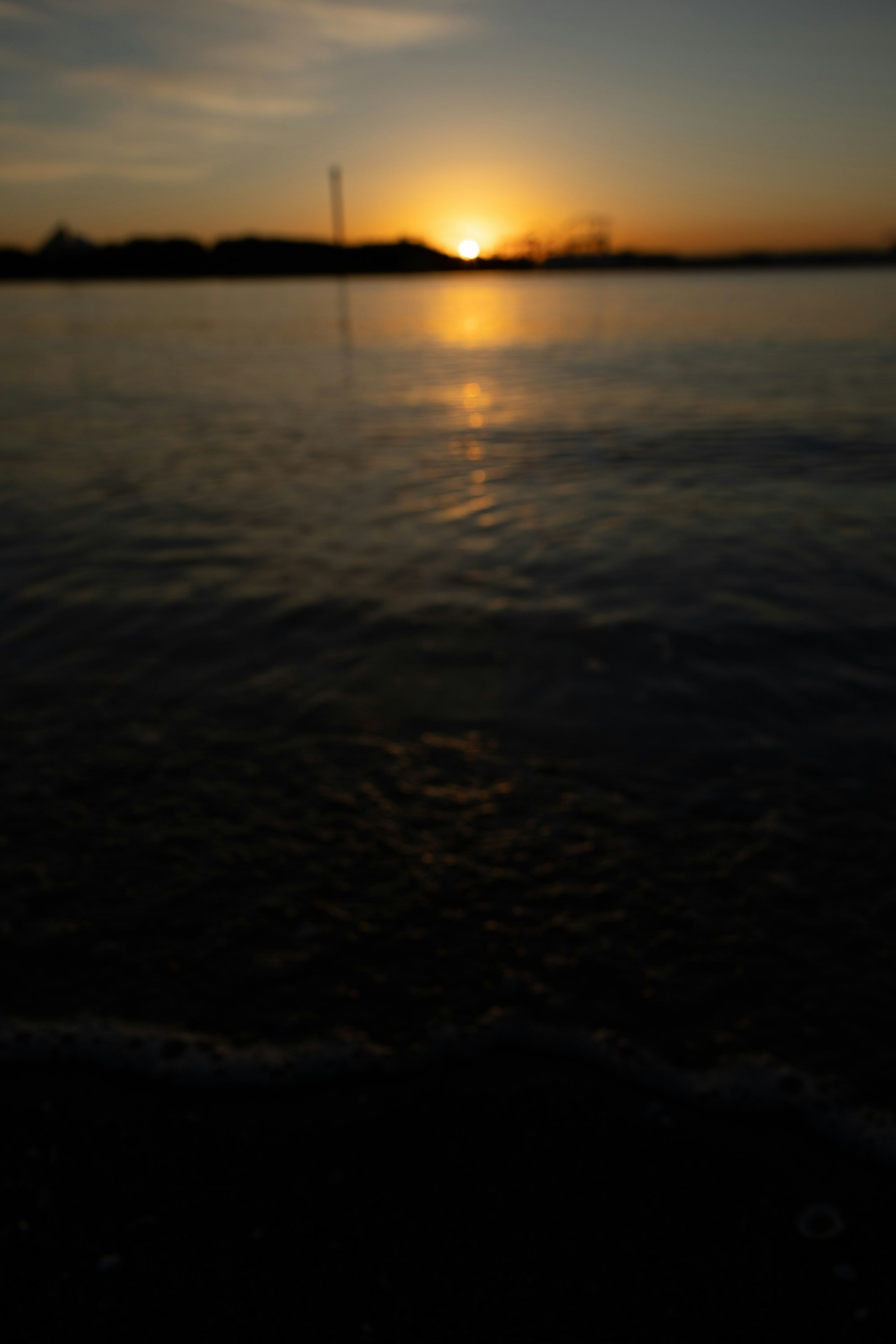 夕日が水面に映る静かな湖の風景