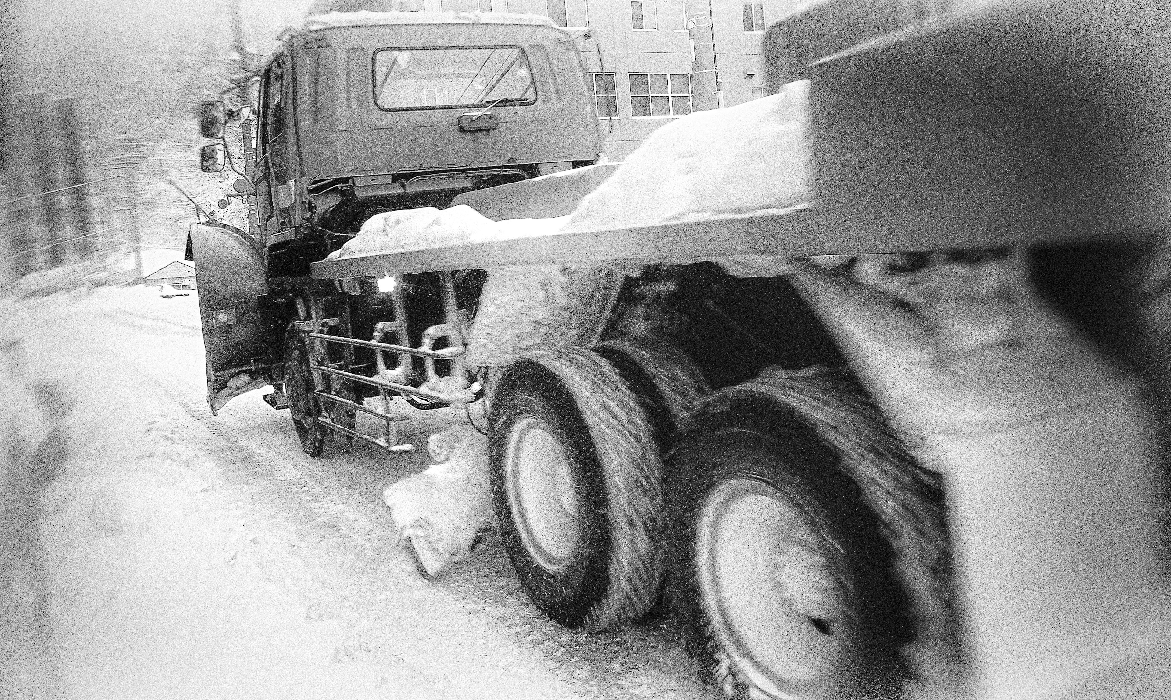 Vue latérale d'un camion circulant sur une route enneigée