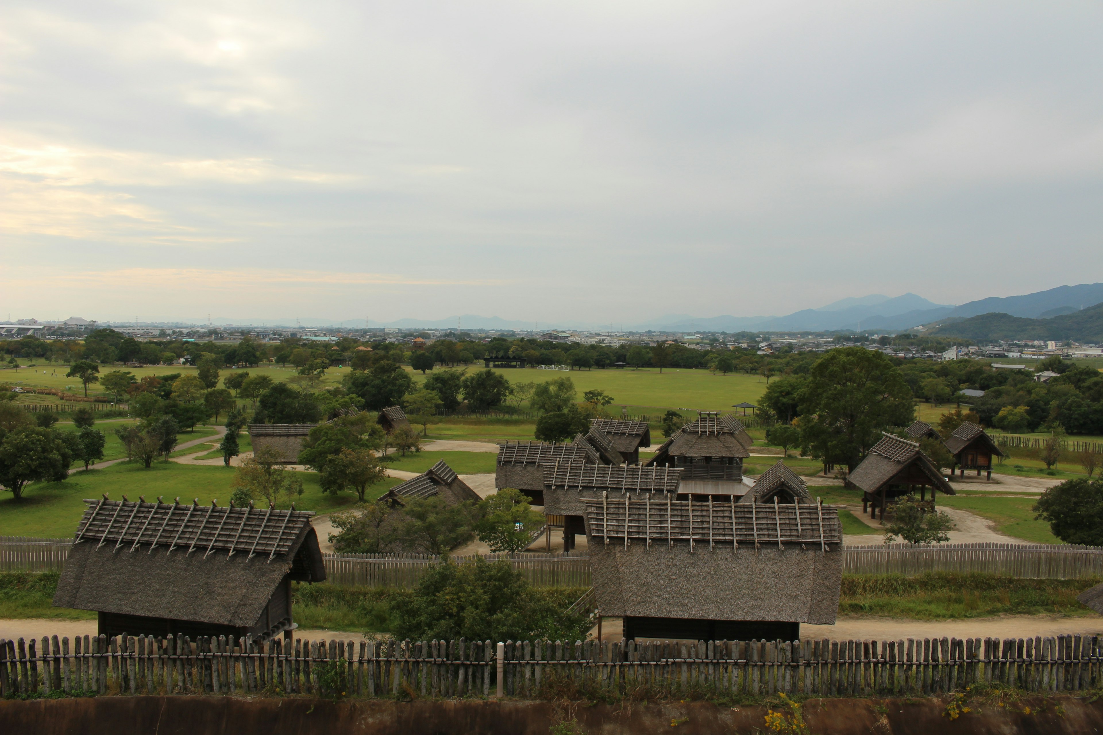 Traditional thatched-roof houses scattered across a lush green landscape