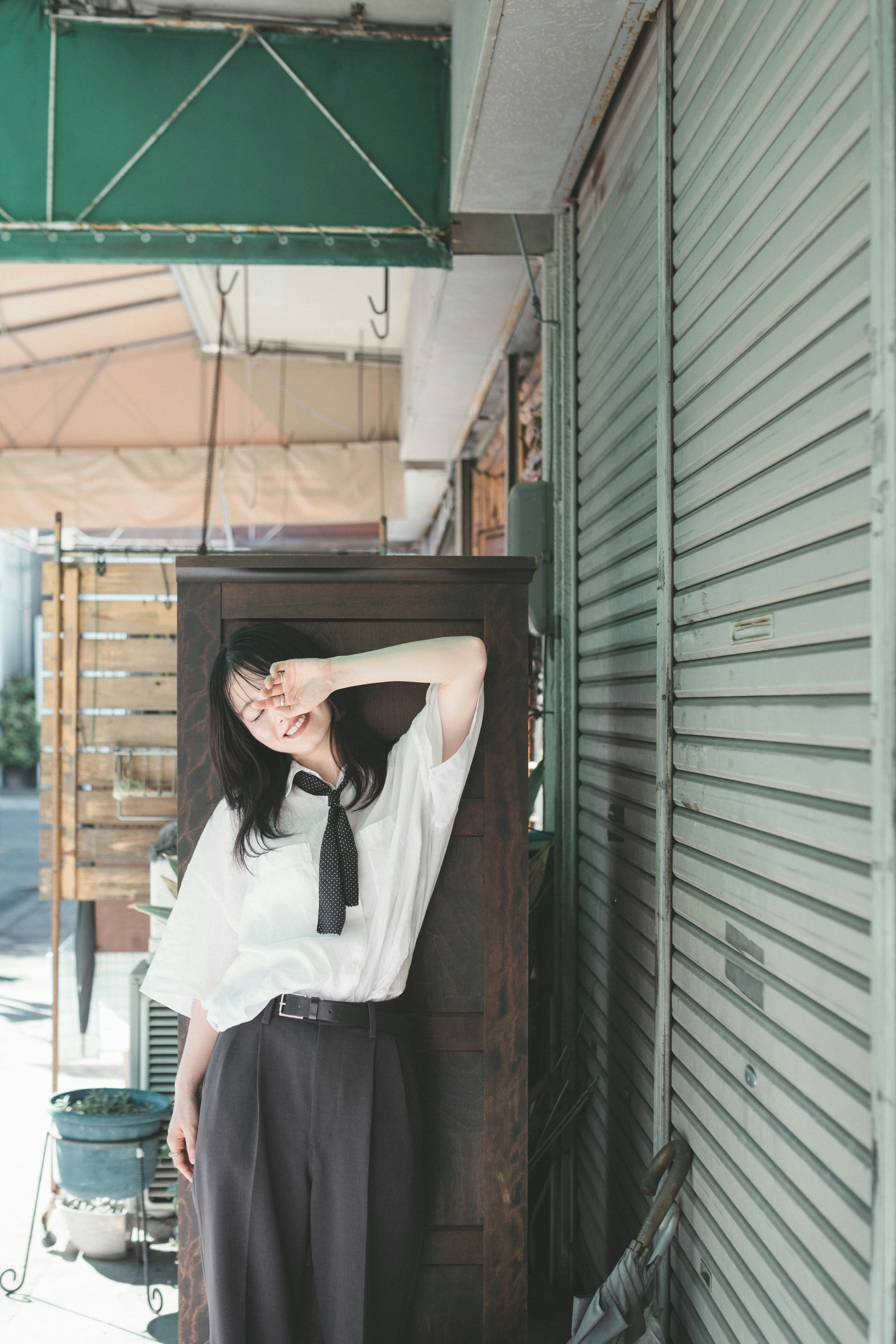 Jeune femme en chemise blanche et pantalon noir posant dans un cadre urbain