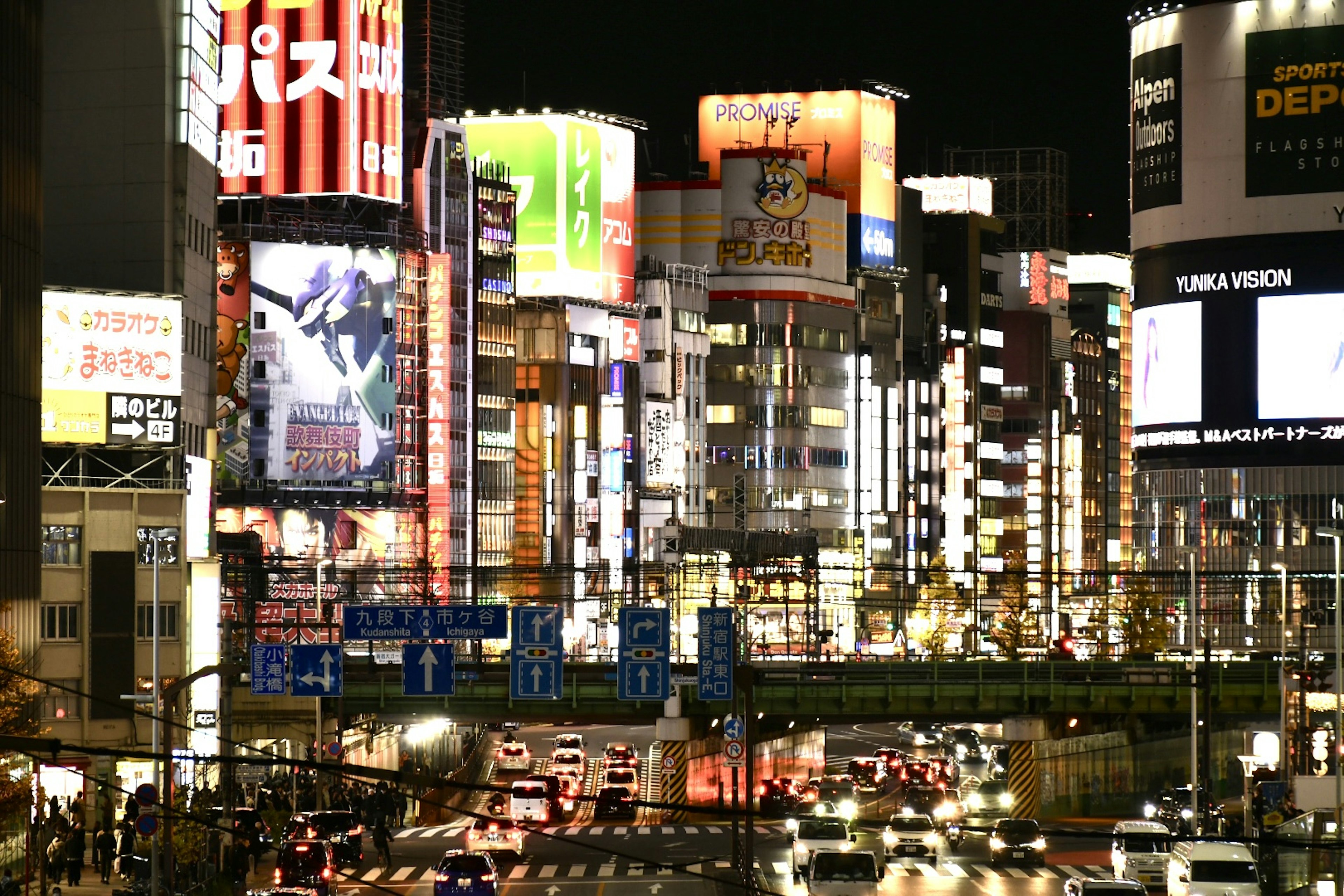 Pemandangan malam kota Shinjuku yang terang benderang dengan papan iklan neon dan lalu lintas yang ramai