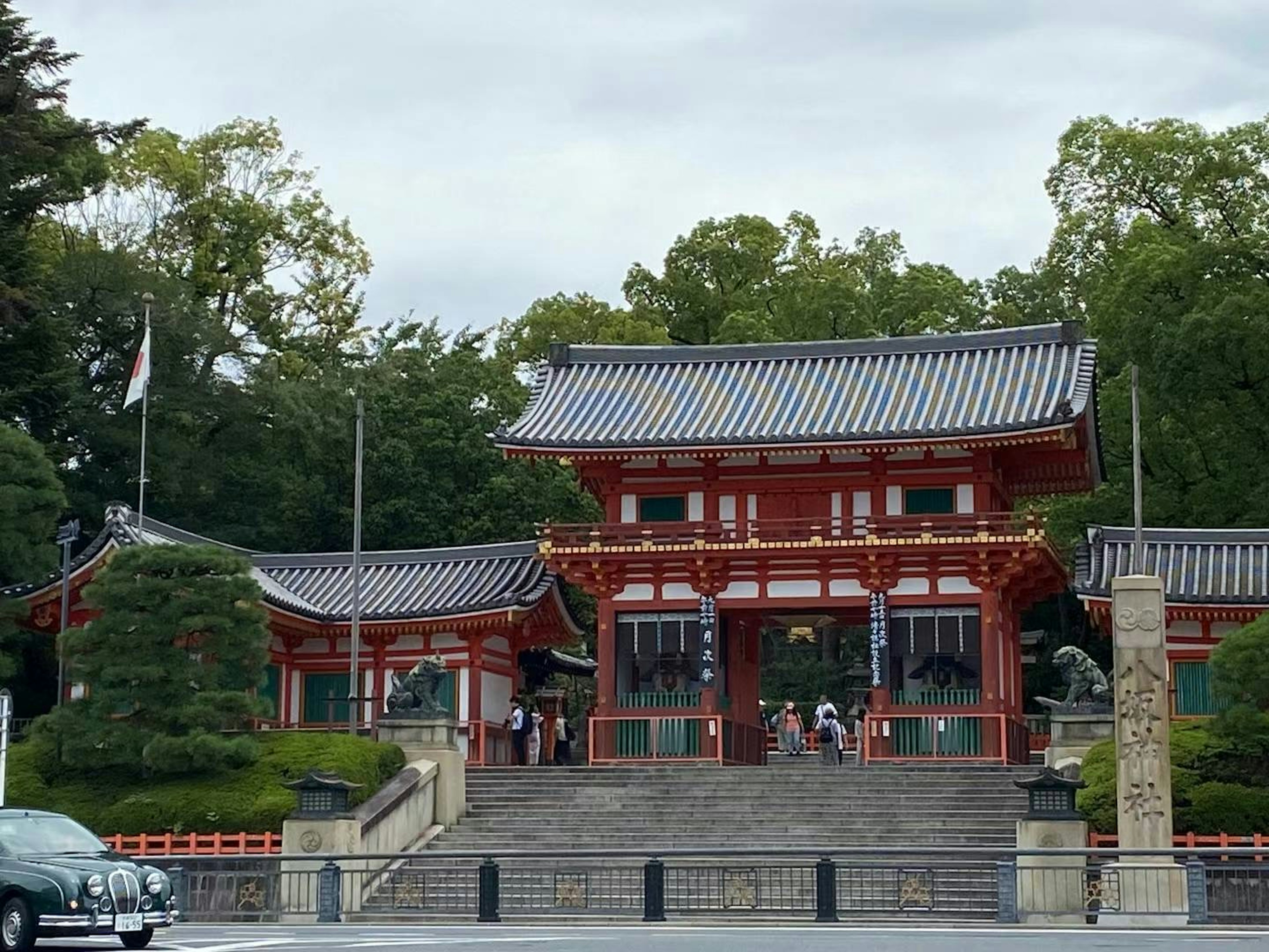 Entrada de un santuario japonés con una hermosa puerta roja y visitantes reunidos