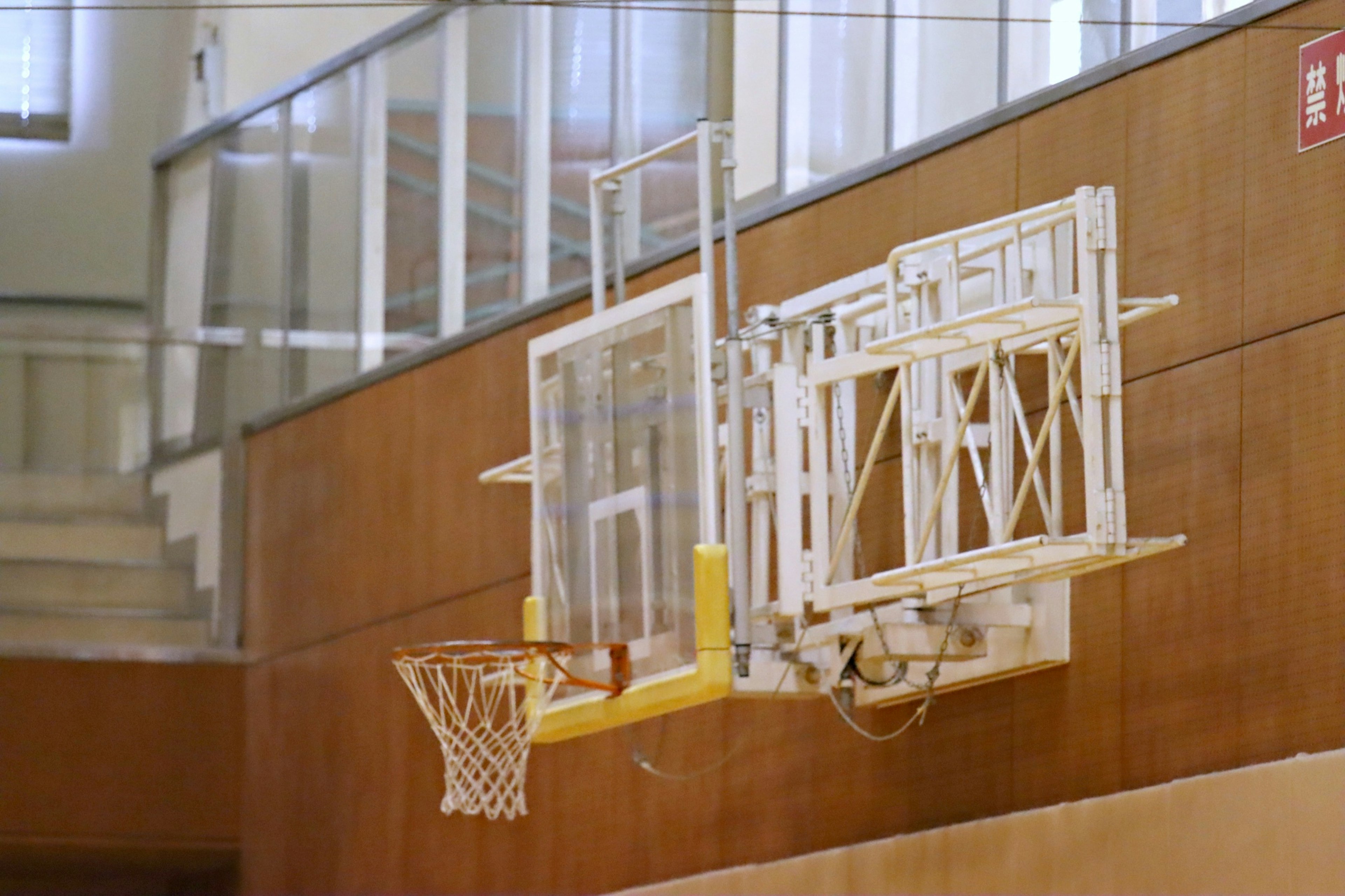 Interno di una palestra con un canestro da basket e un tabellone