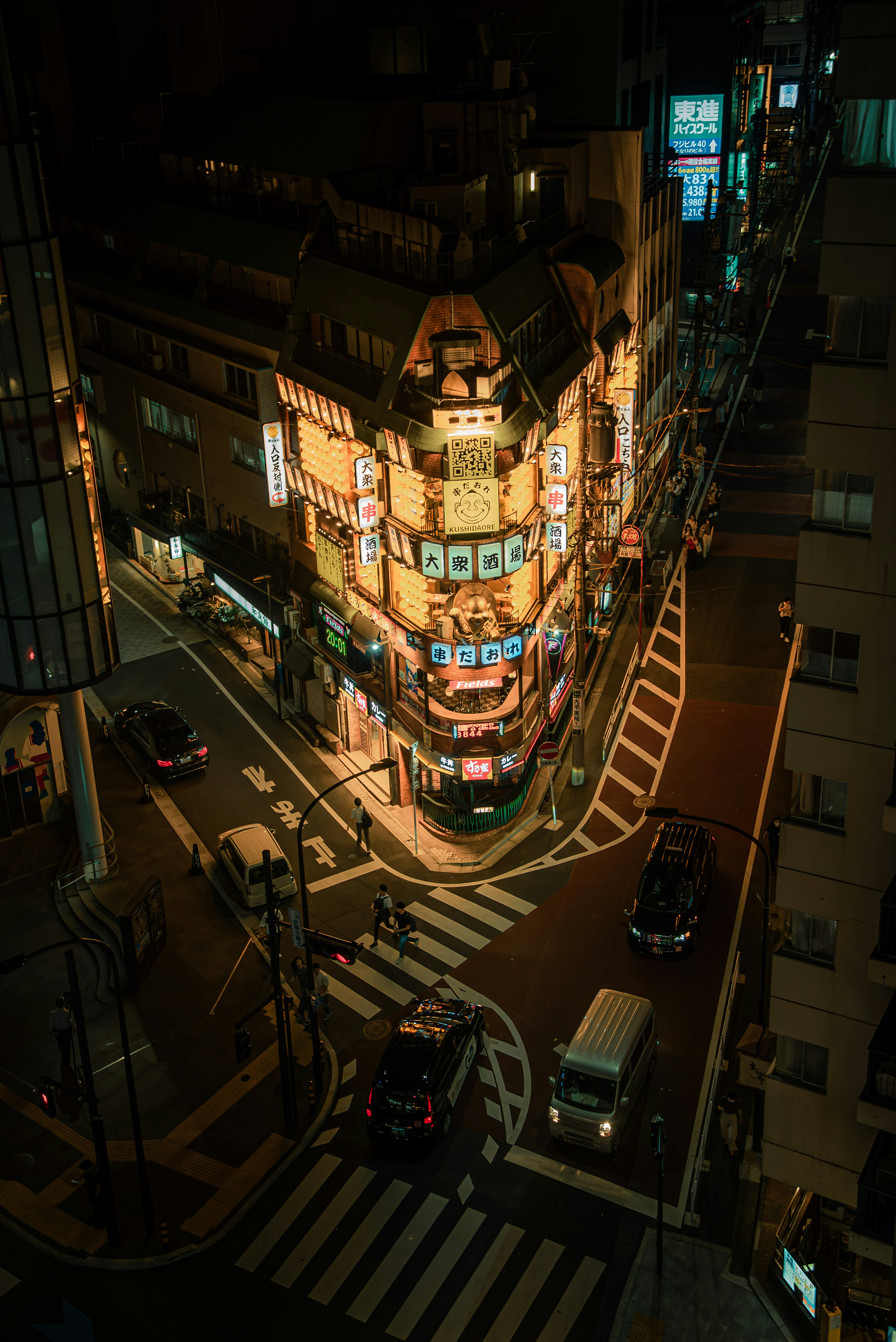 Escena nocturna de un edificio iluminado en una esquina de la calle