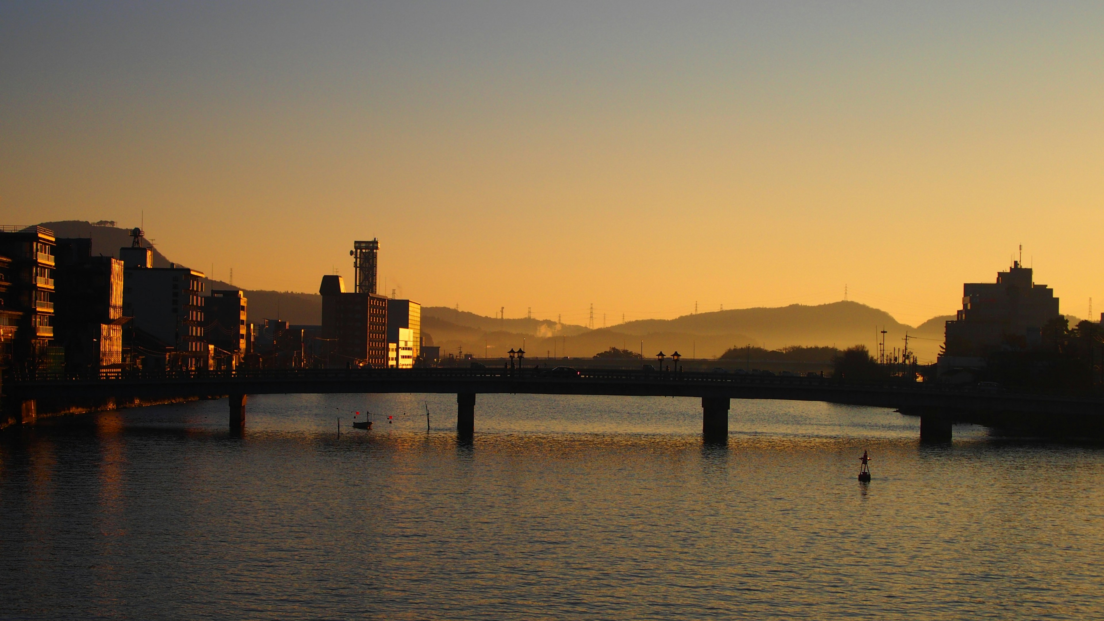 Escena de río y puente con atardecer