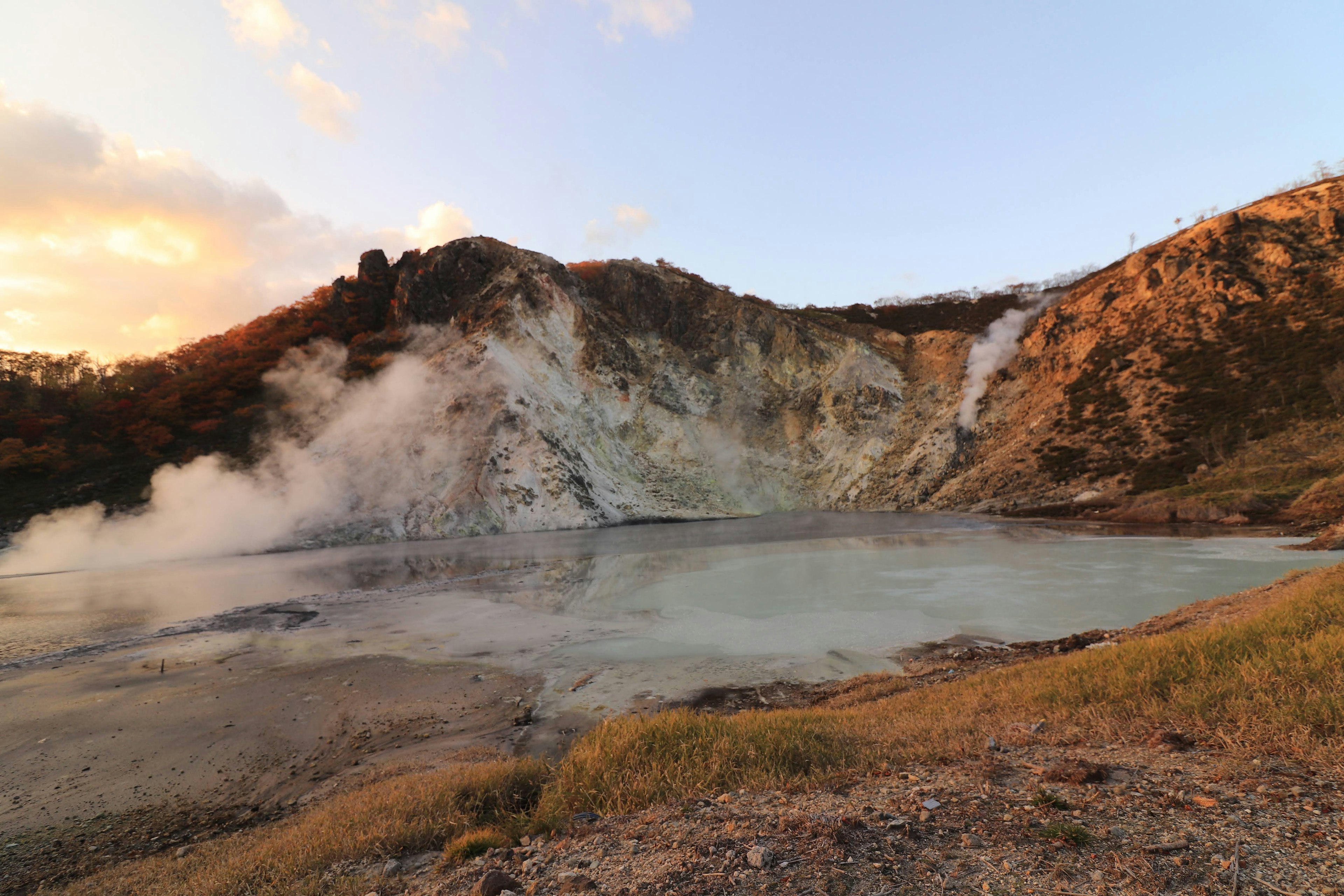 ทิวทัศน์ภูเขาที่สวยงามพร้อมน้ำพุร้อนที่มีไอน้ำ