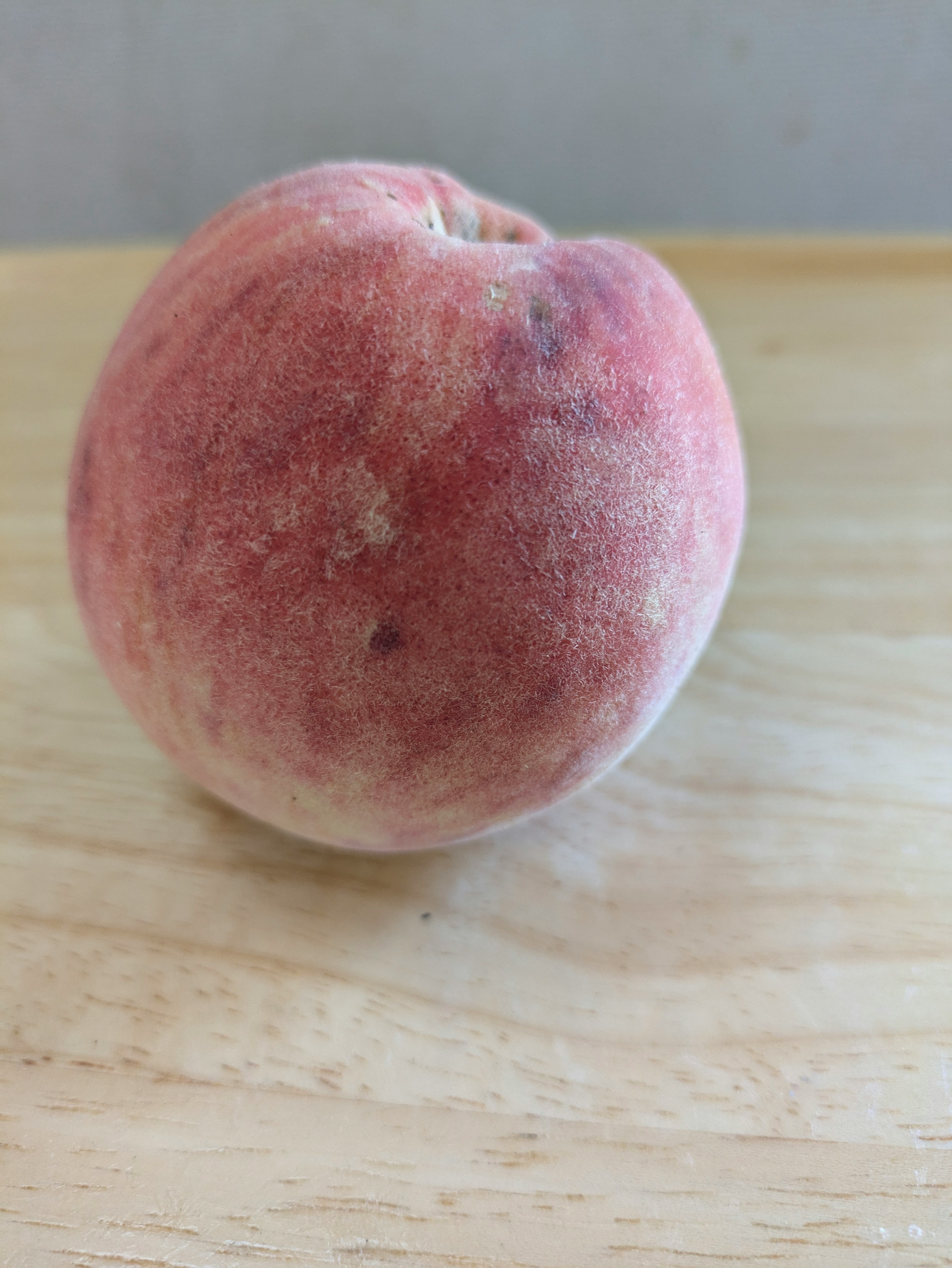 Ein lebendiger Pfirsich auf einem Holztisch