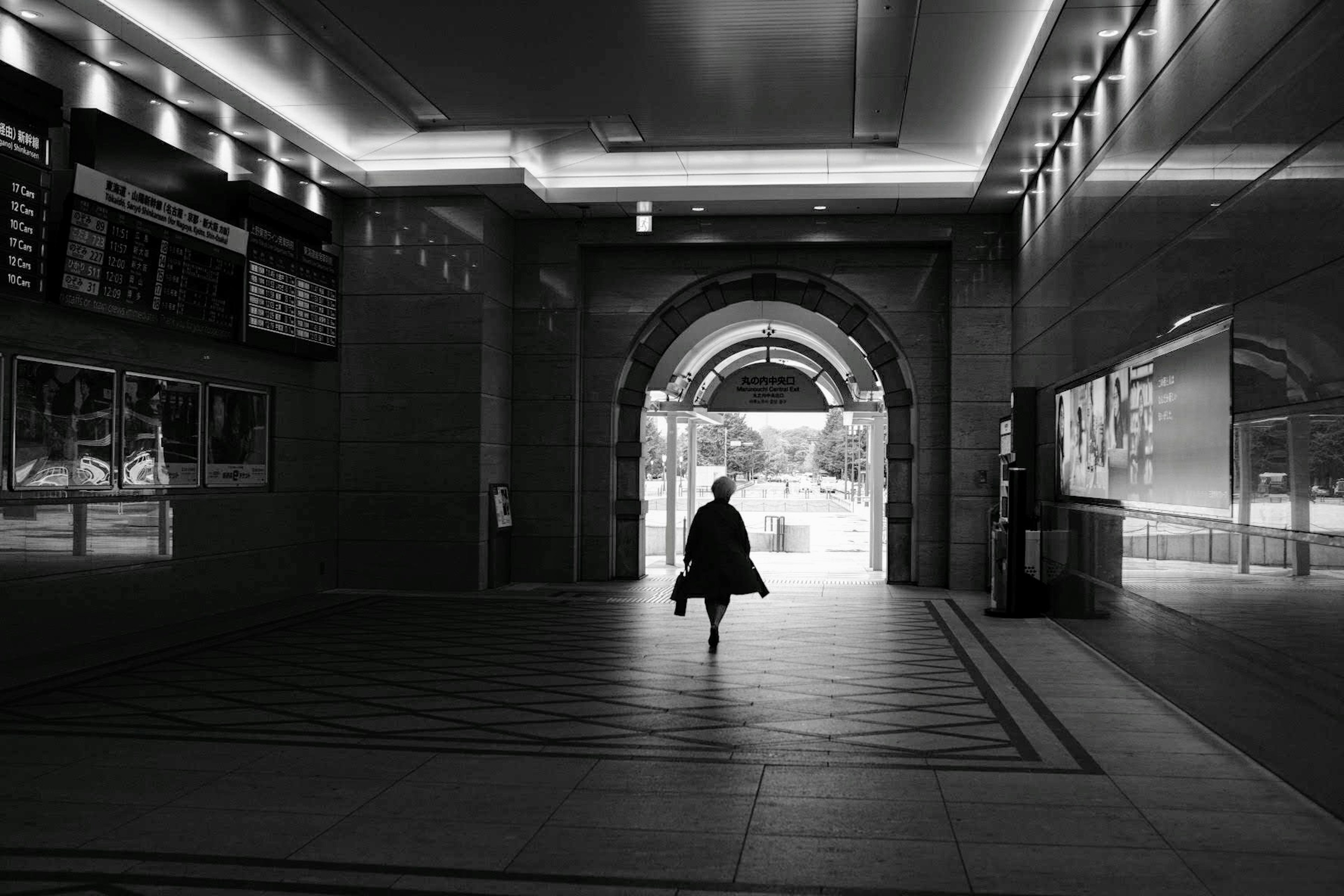 Silhouette di una persona che esce da un tunnel scuro verso un paesaggio luminoso all'aperto