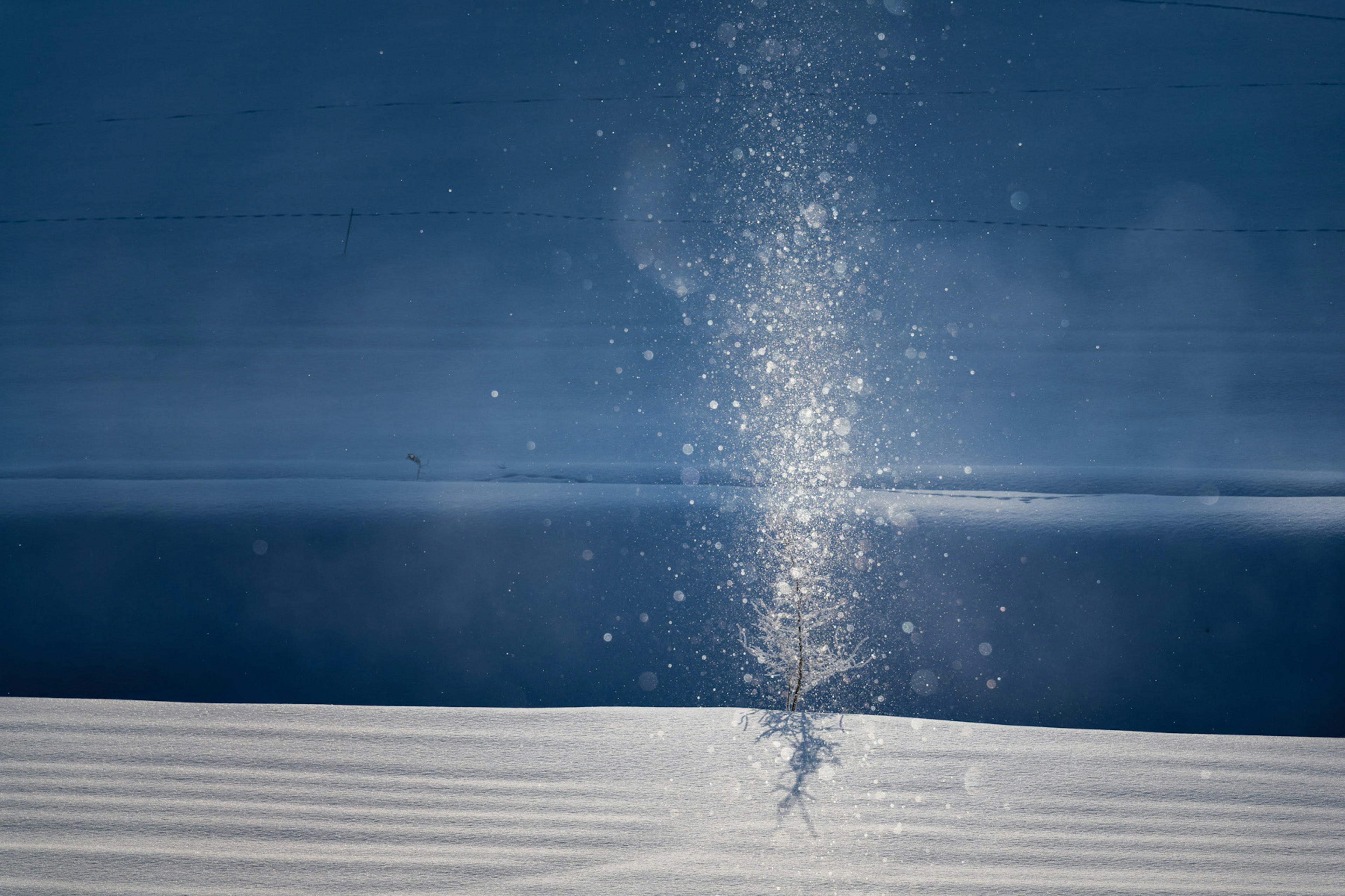 Sparkling water spray against a backdrop of blue sea and white snow