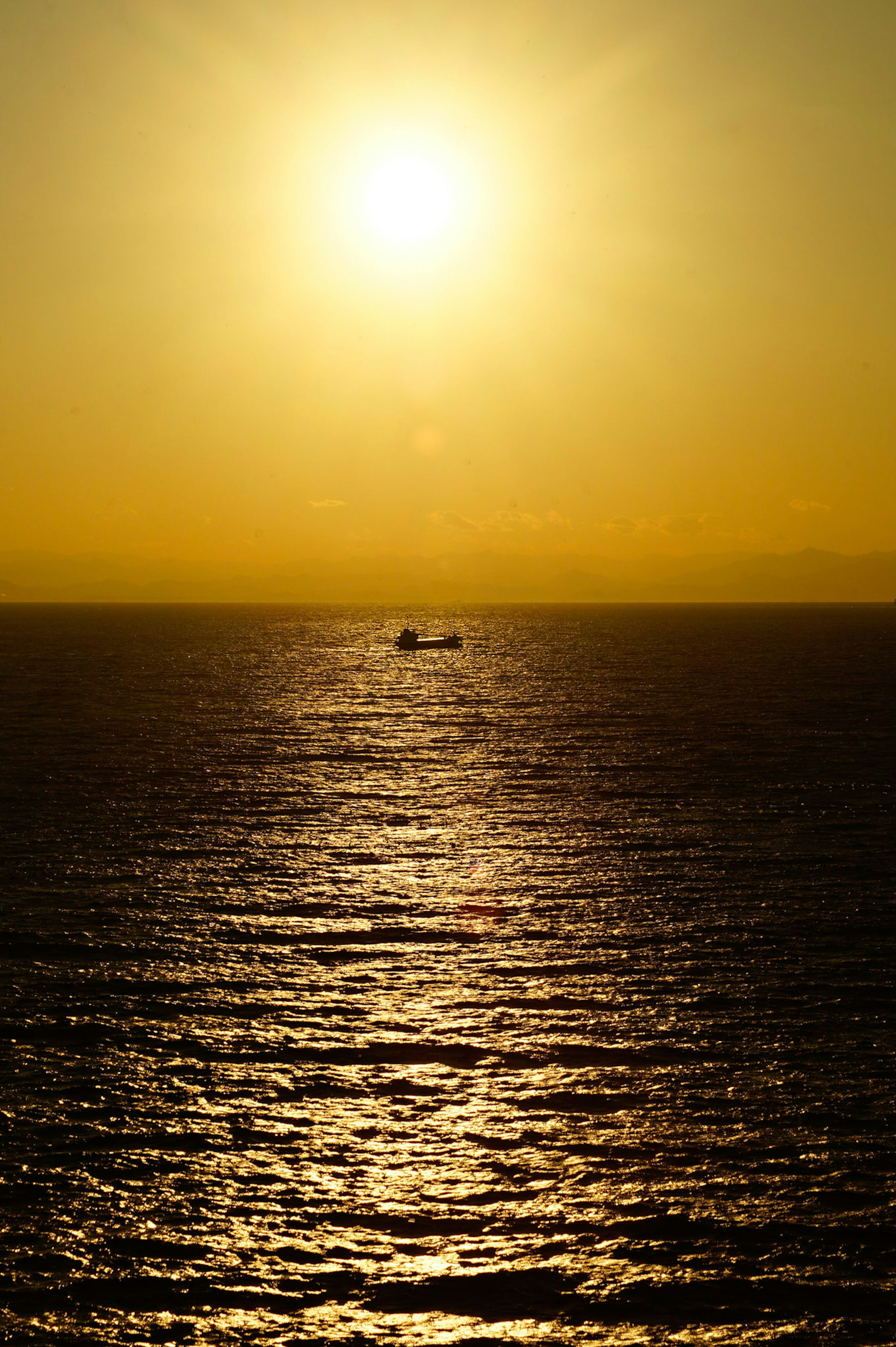 海に浮かぶ船と黄昏の太陽