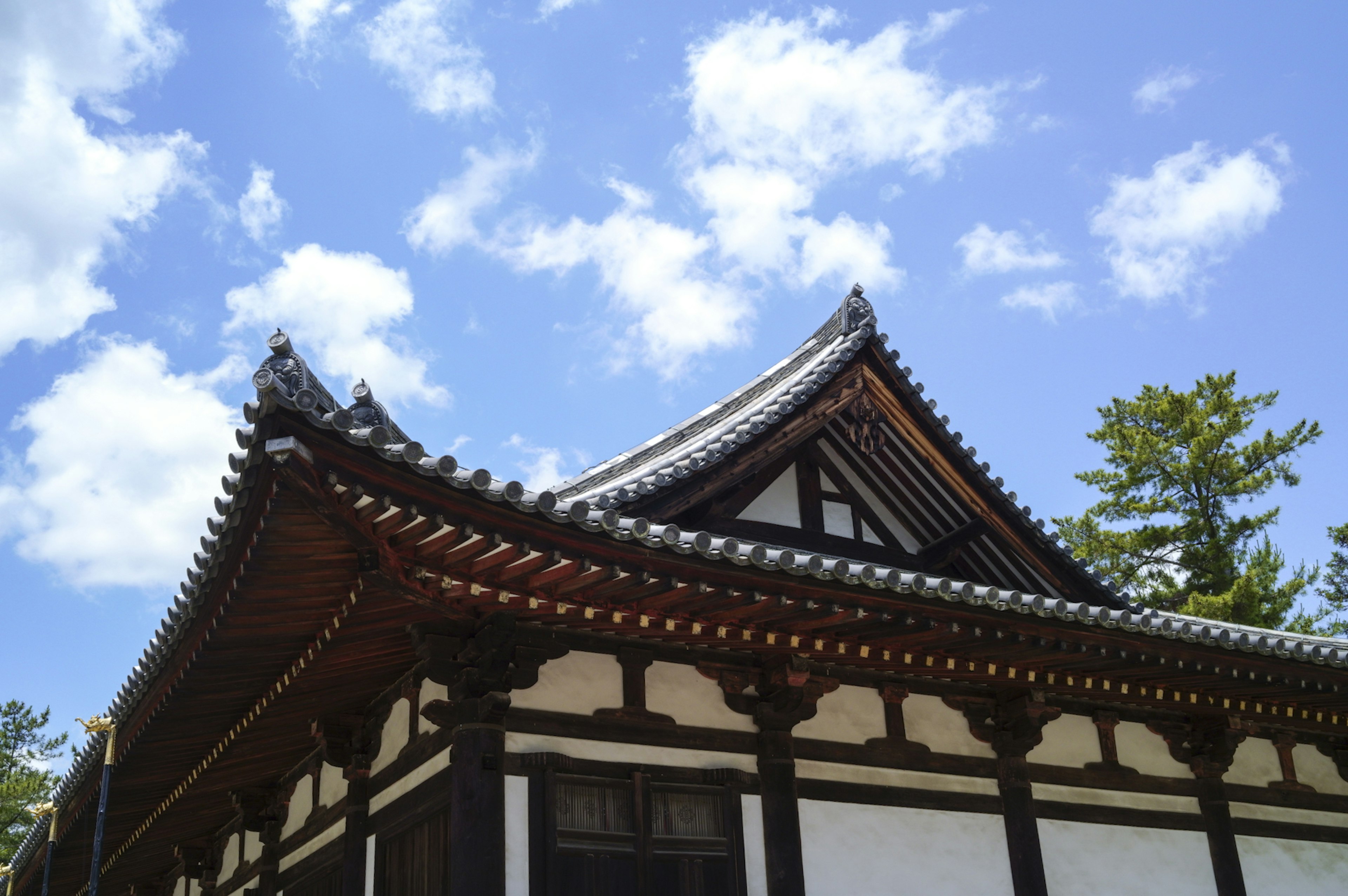 Traditional Japanese architecture featuring a curved roof against a blue sky