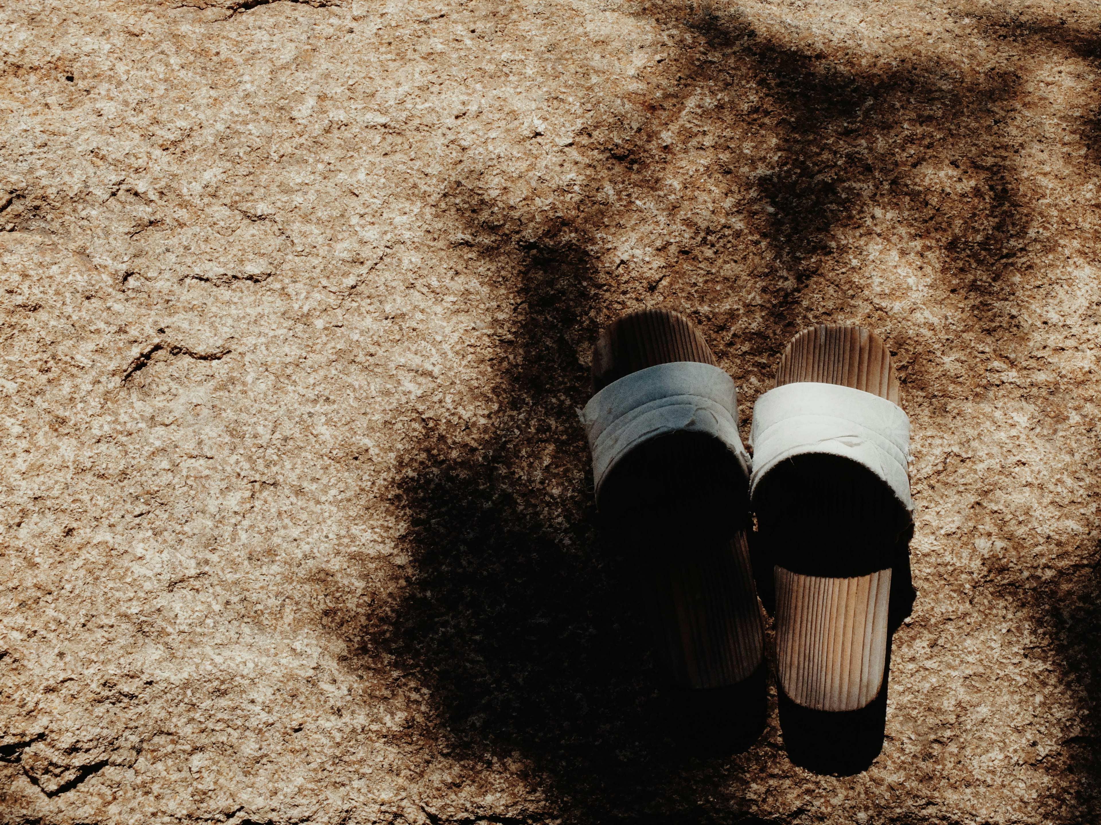 Sandalias deslizantes blancas y negras colocadas bajo la luz del sol