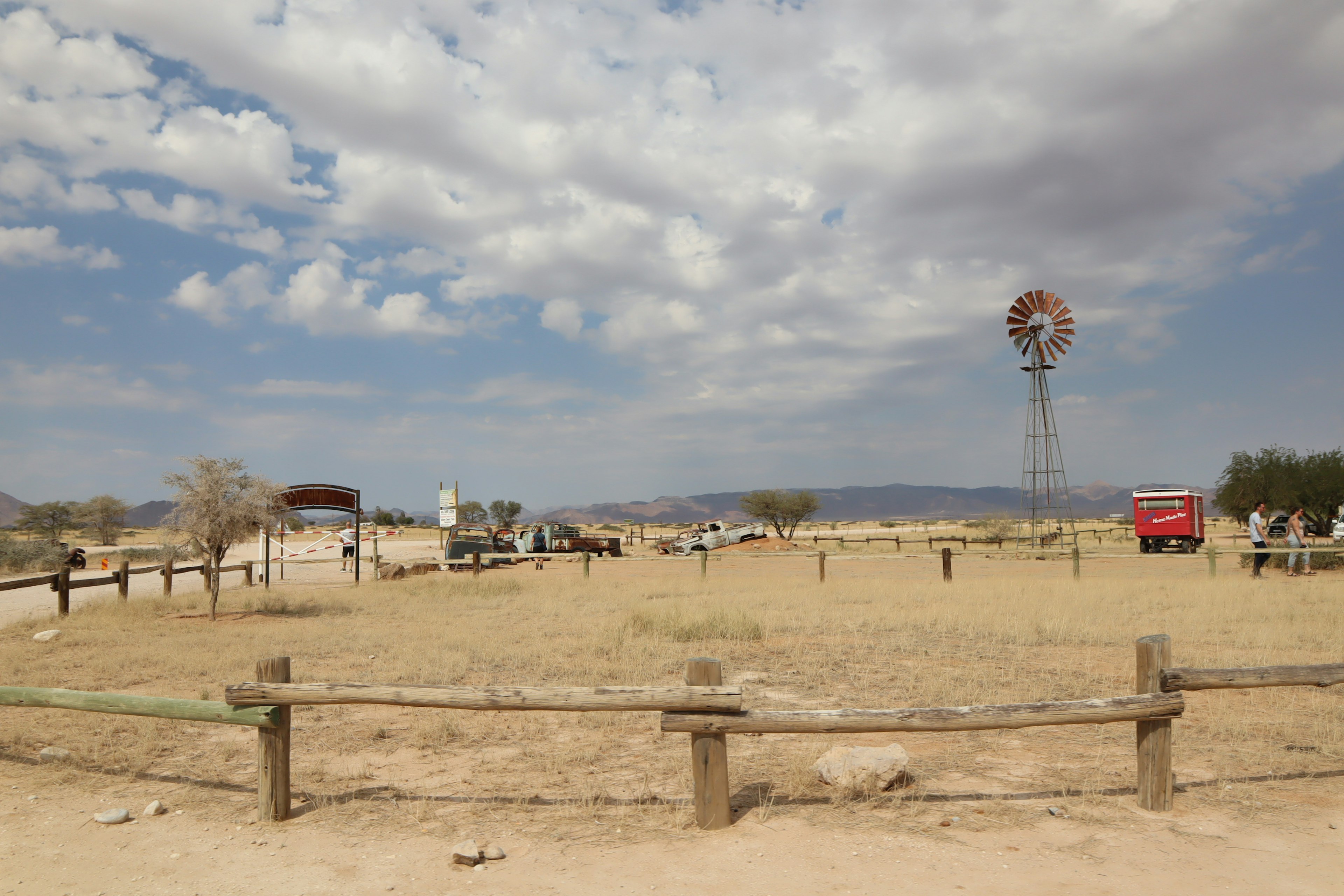 Dry landscape featuring a wooden fence and a windmill