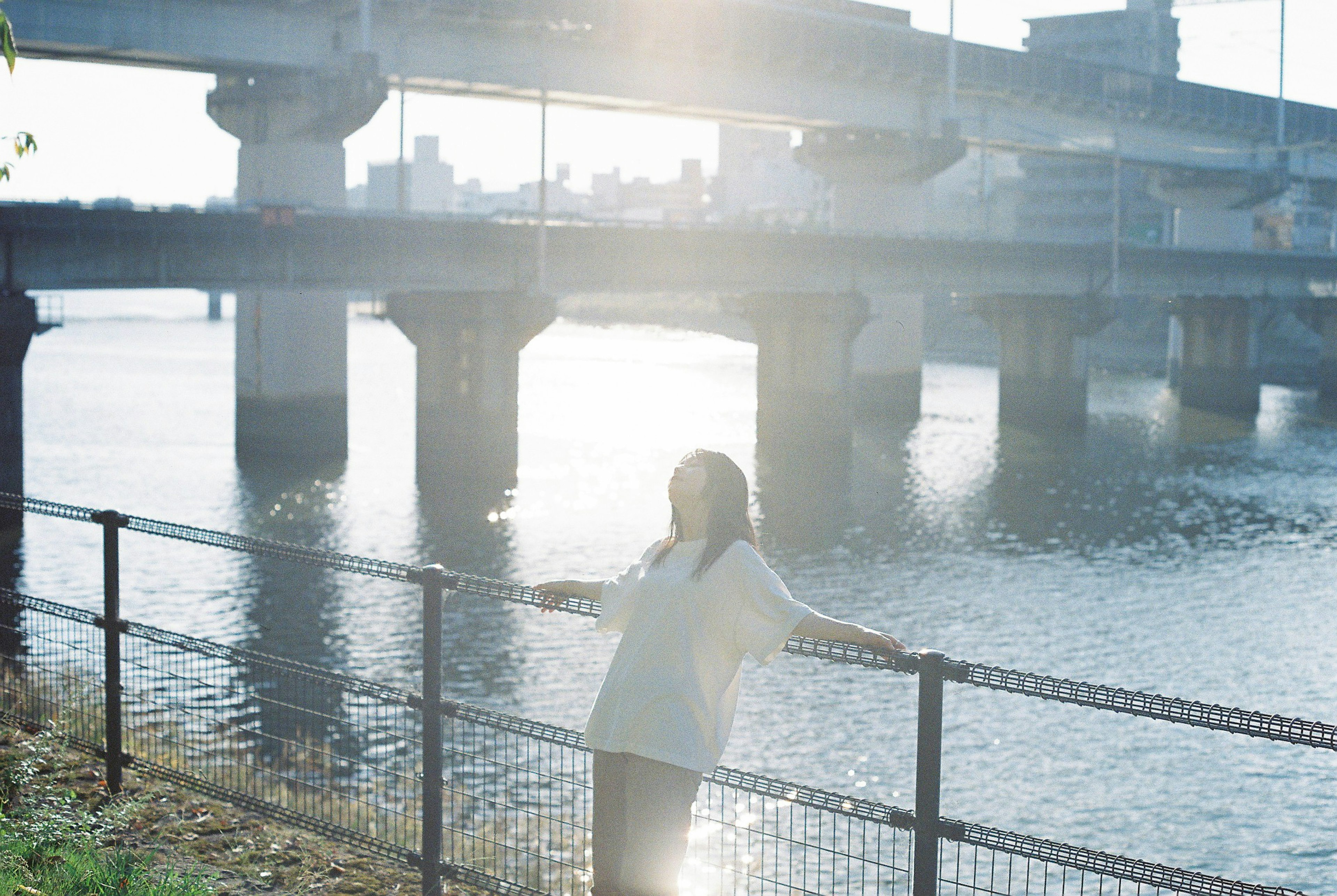 川辺でリラックスする女性と橋の風景