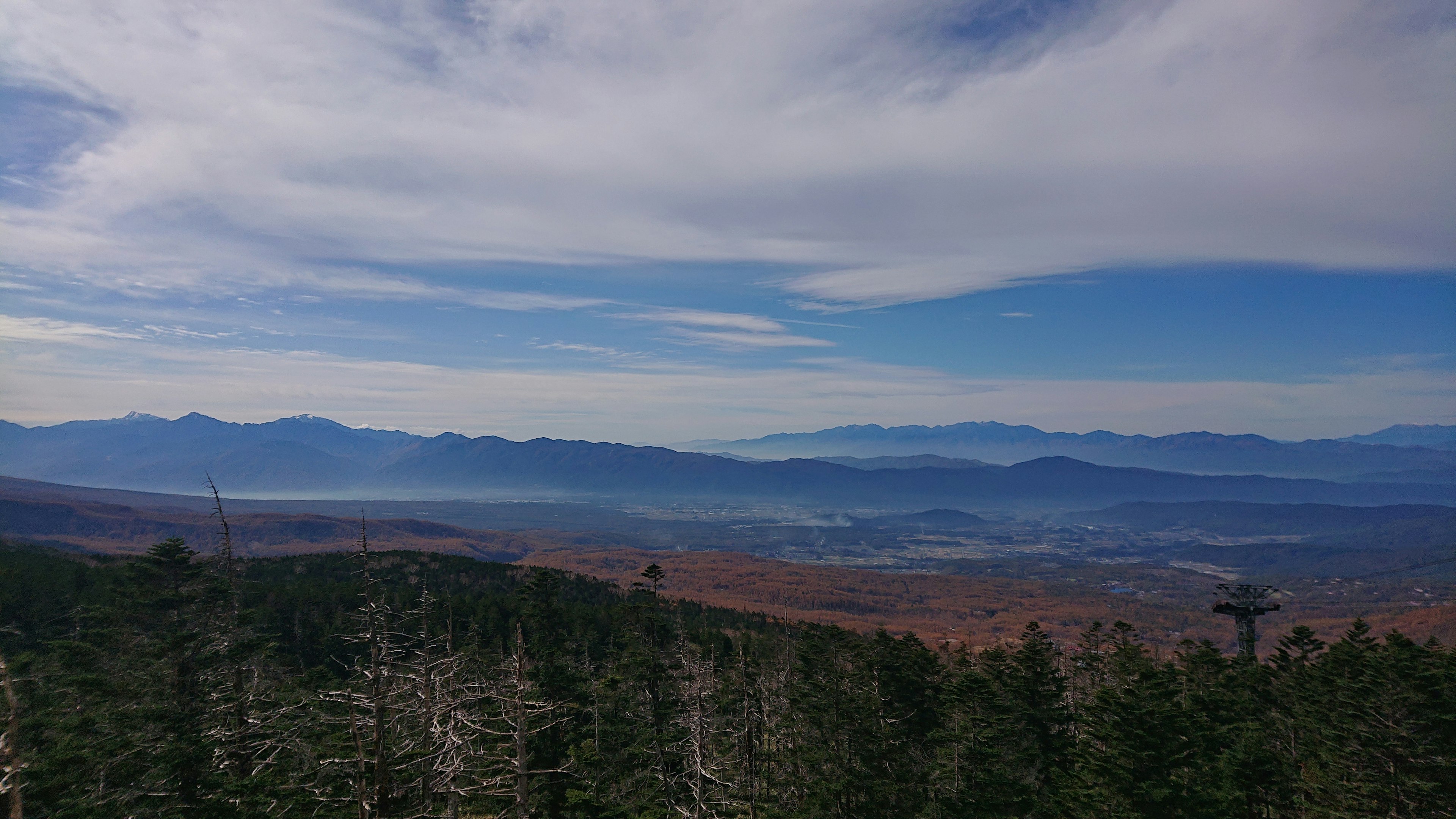 Mountain landscape with blue sky and clouds overlooking green forests