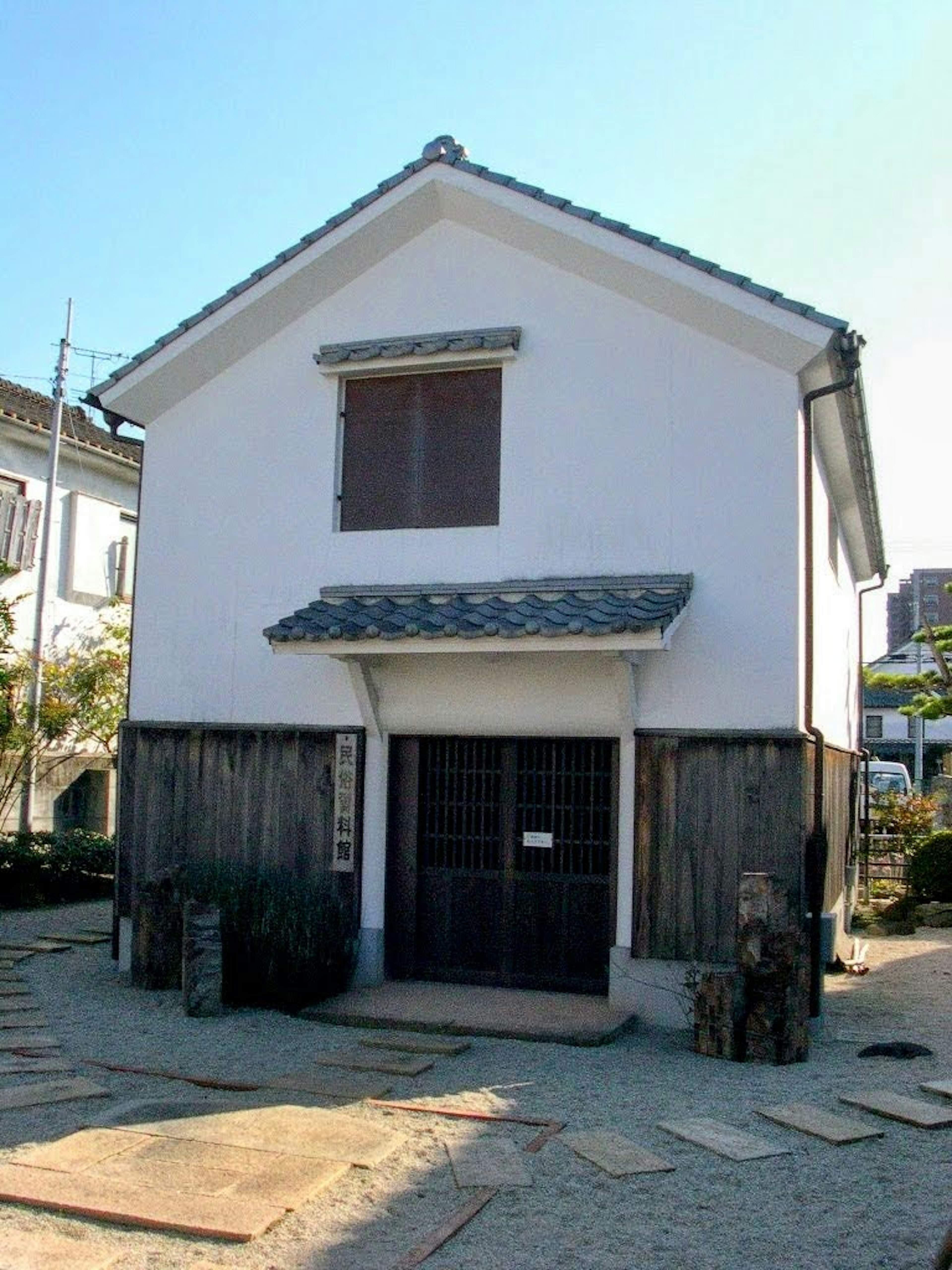 Traditional Japanese house with white exterior wooden door and tiled roof