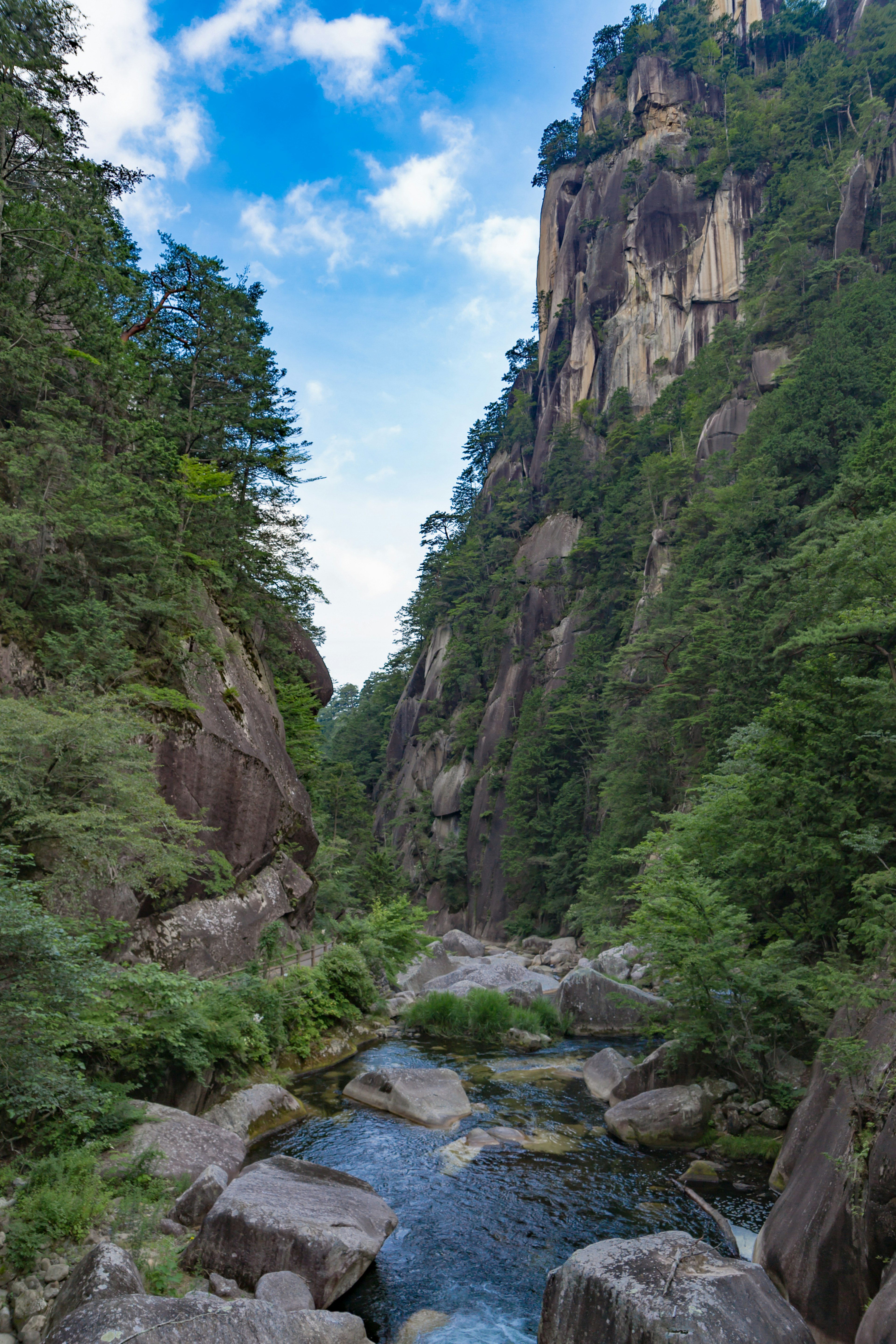 Valle escénica con un arroyo claro y acantilados rocosos imponentes