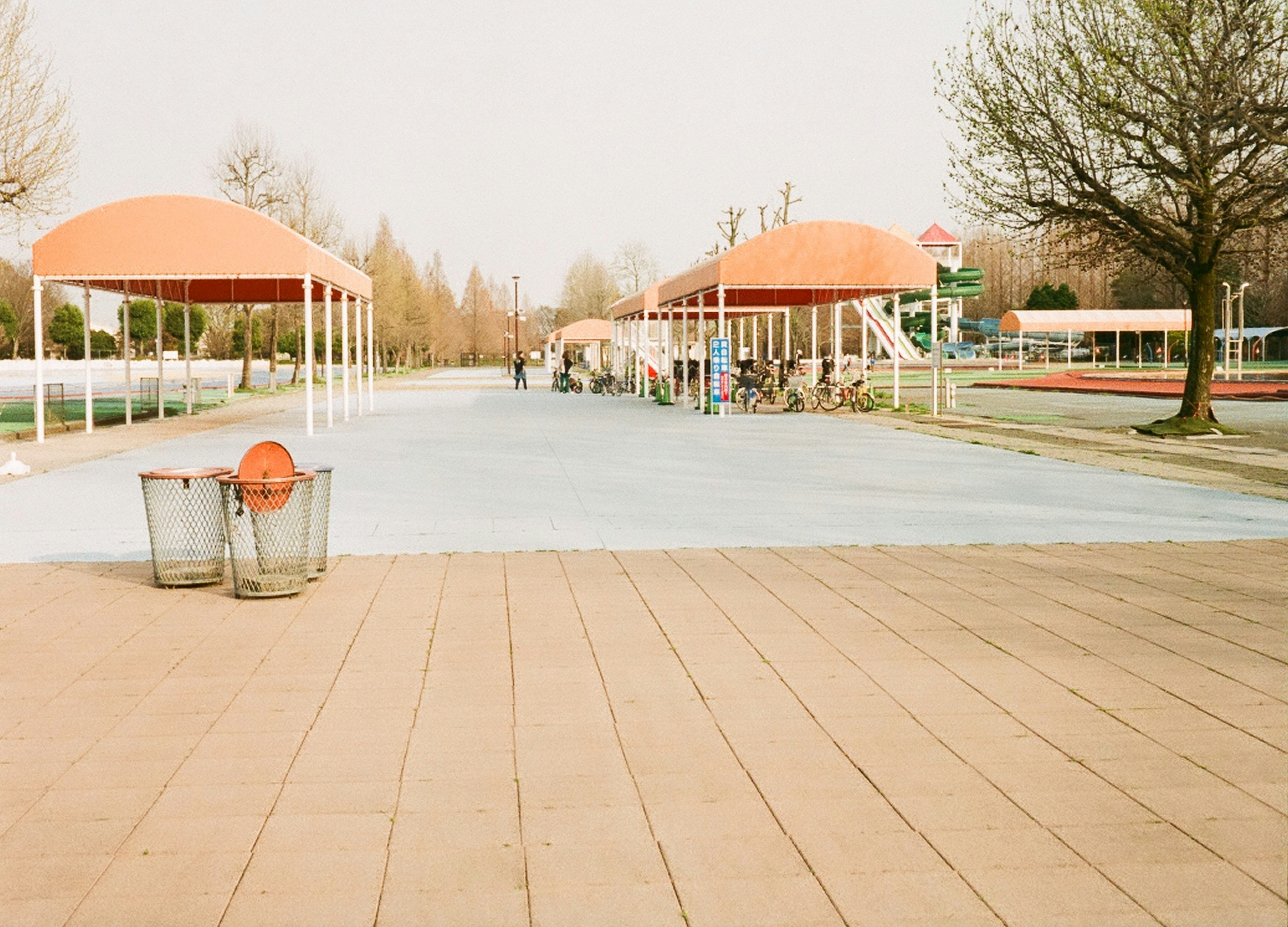 Vue du parc avec des pavillons à toit orange et un sol bleu clair