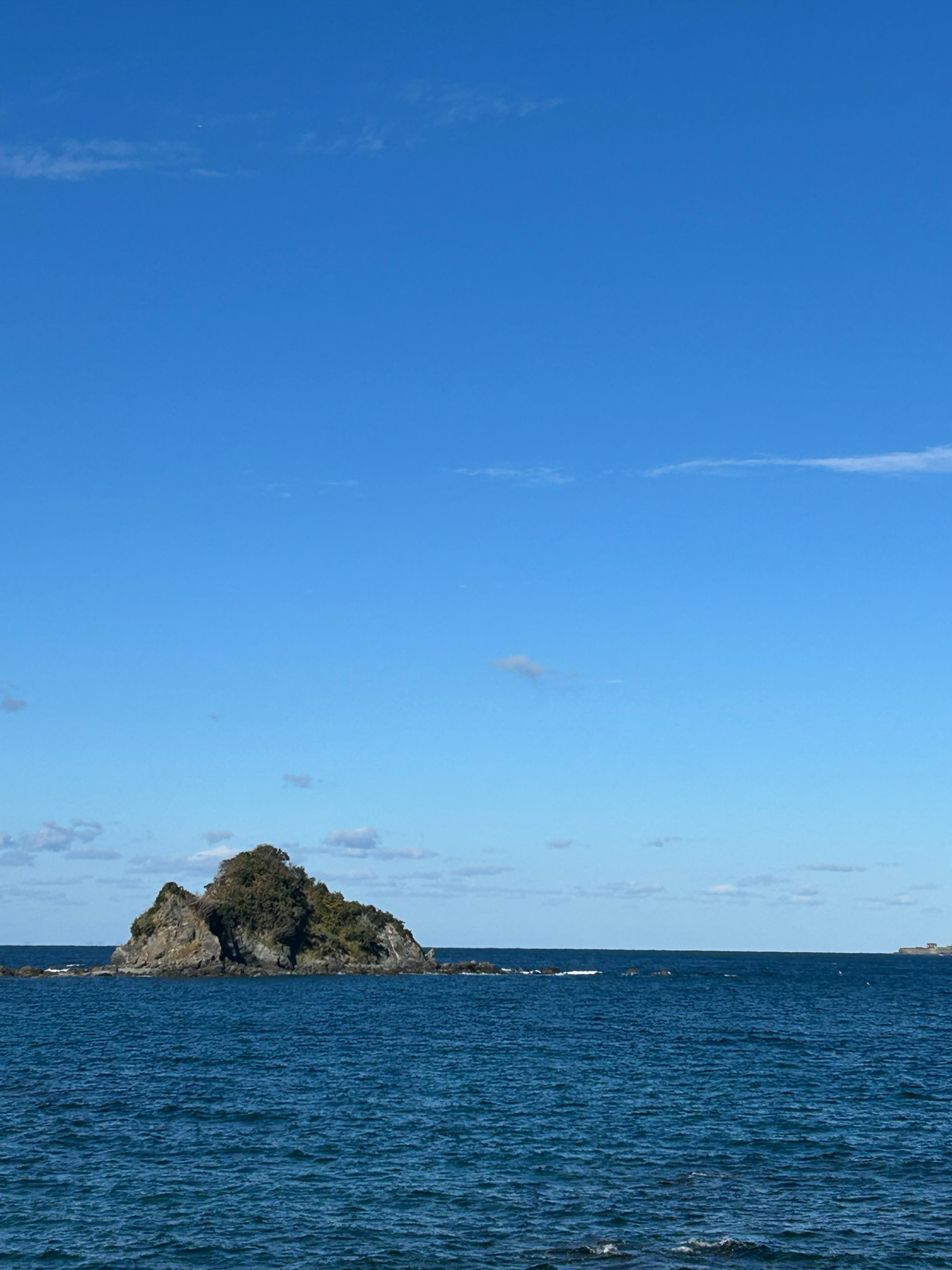 青い海と大空に浮かぶ小さな島の風景