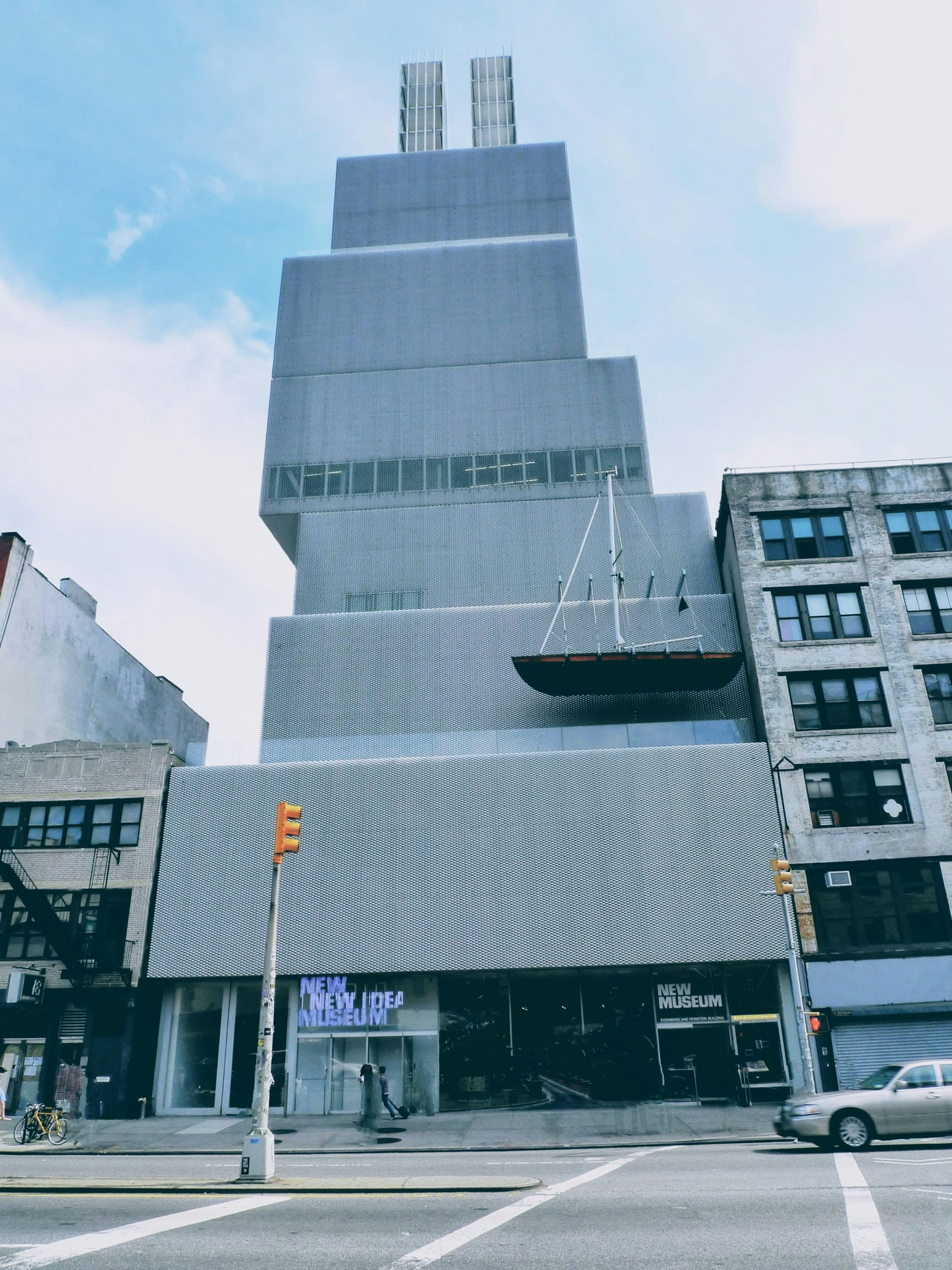 Facciata di un edificio moderno con esterno grigio e una forma di barca distintiva all'angolo di una strada di New York