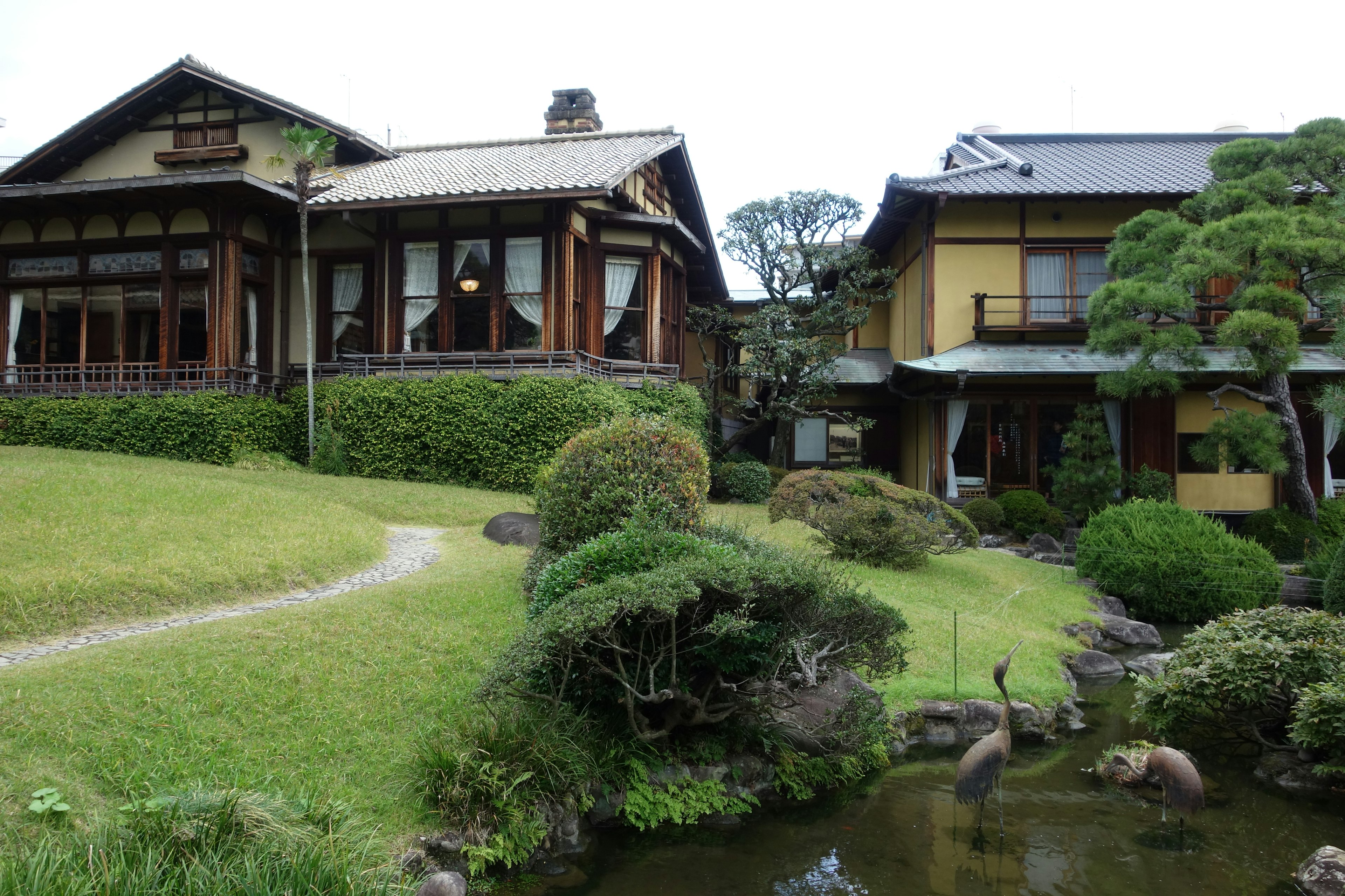 日本の伝統的な家屋が庭に囲まれている風景