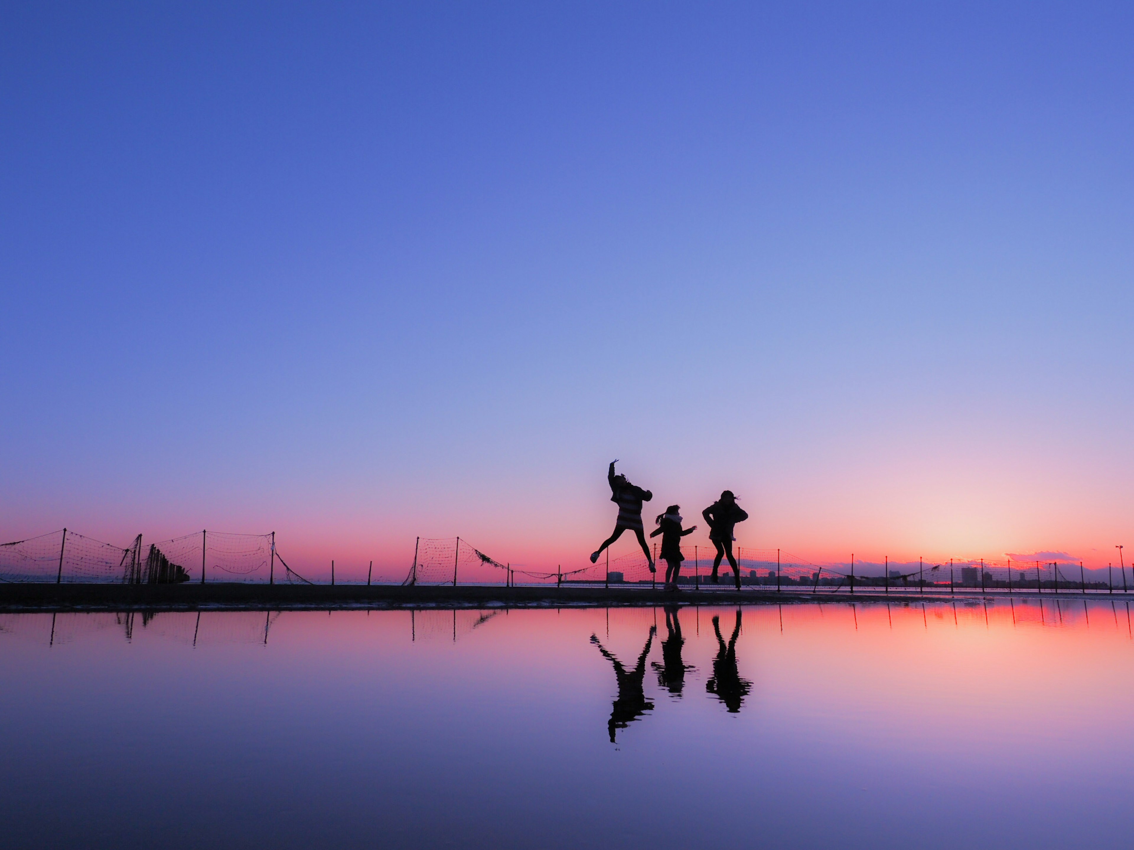 在夕陽天空下享受的人們的輪廓