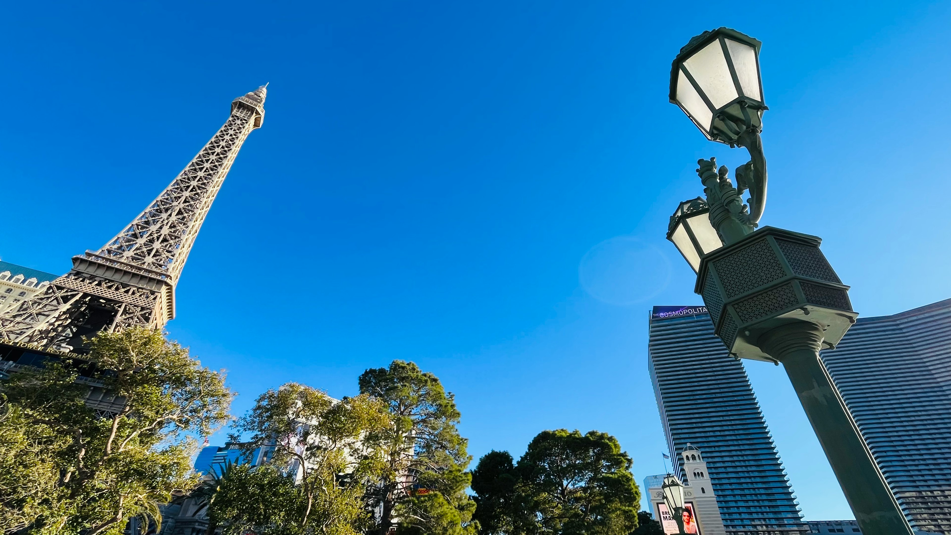 Foto della torre Eiffel e di un lampione con cielo blu chiaro