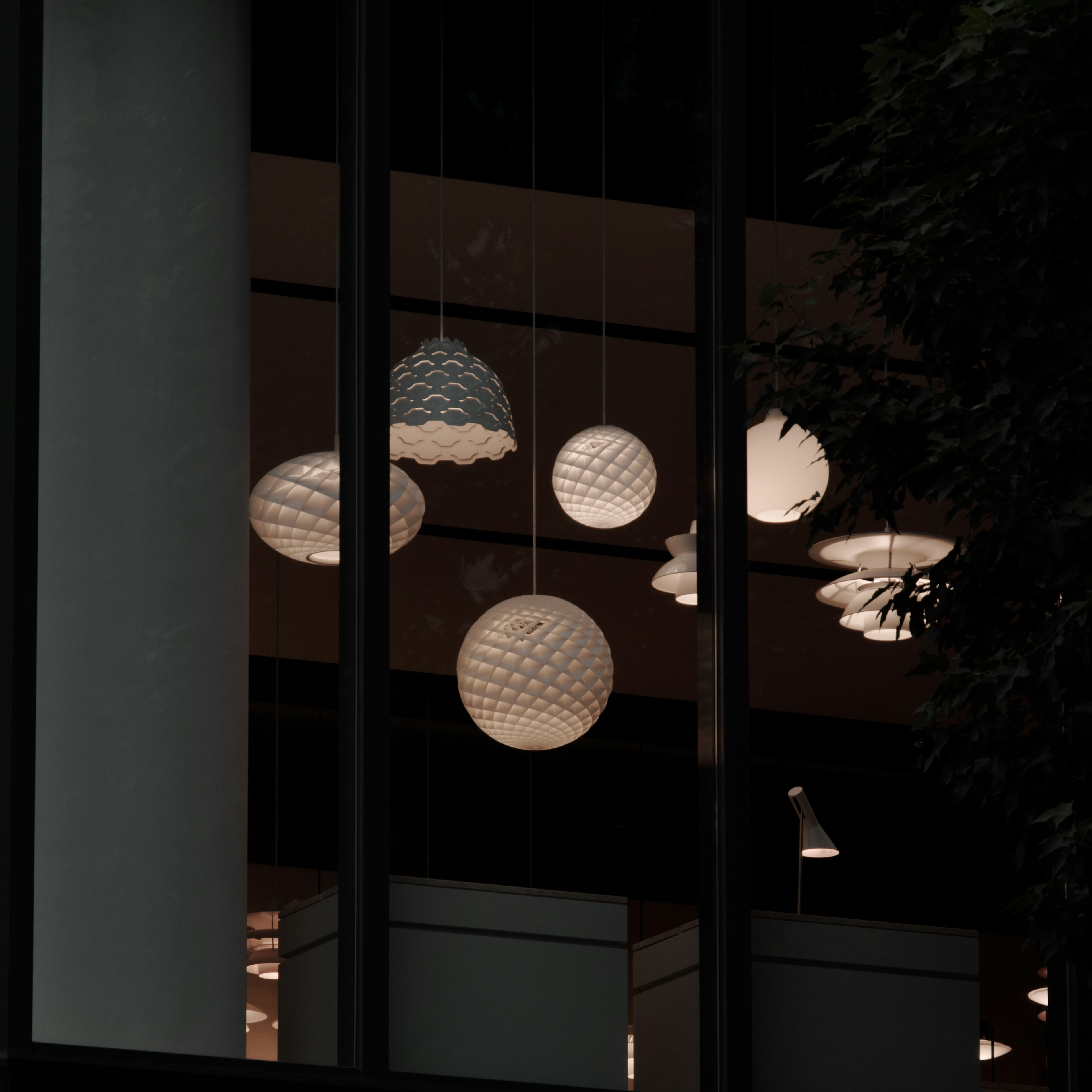 Various pendant lights with unique designs seen through a window