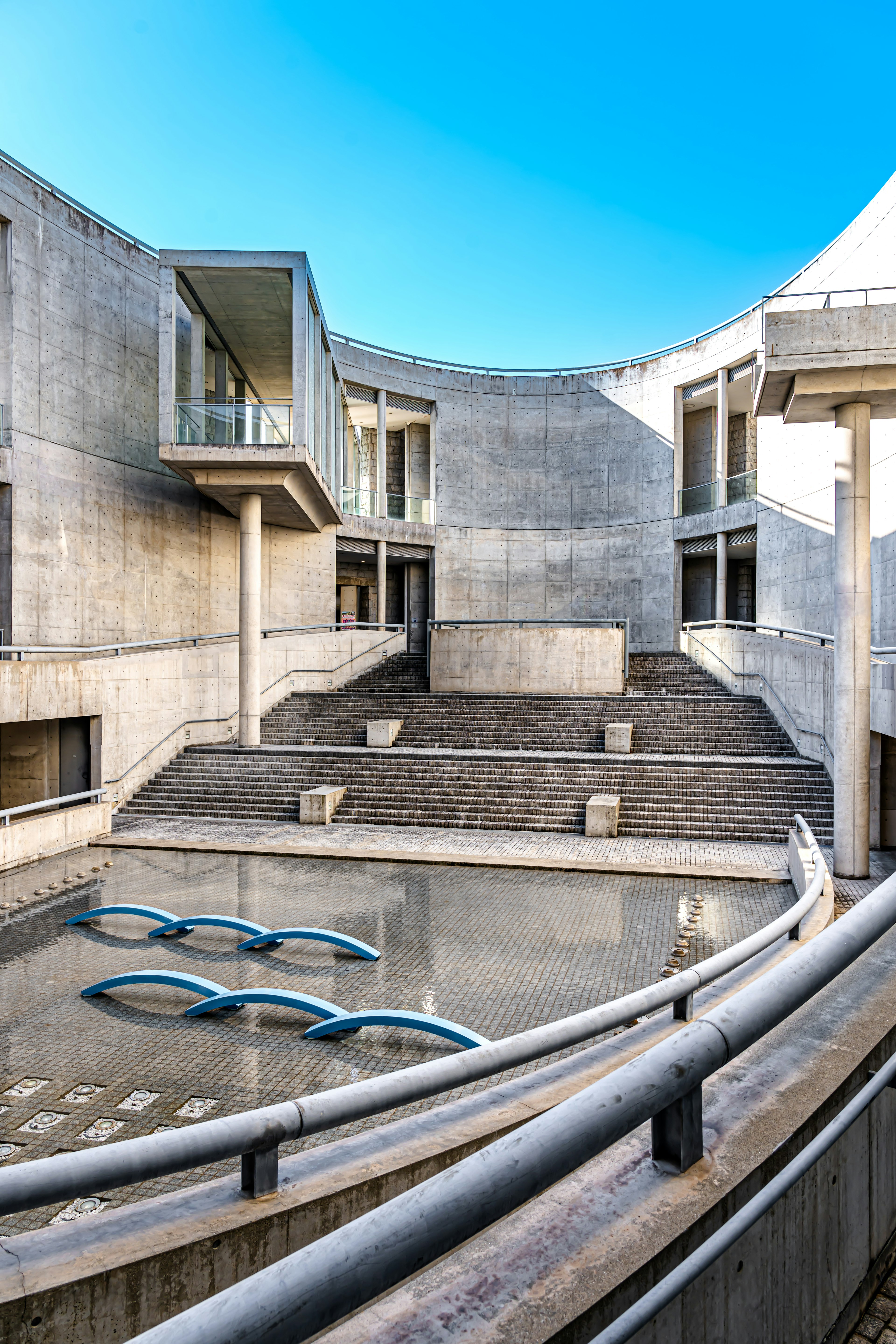 Espacio arquitectónico moderno con estructuras de concreto y una piscina de agua