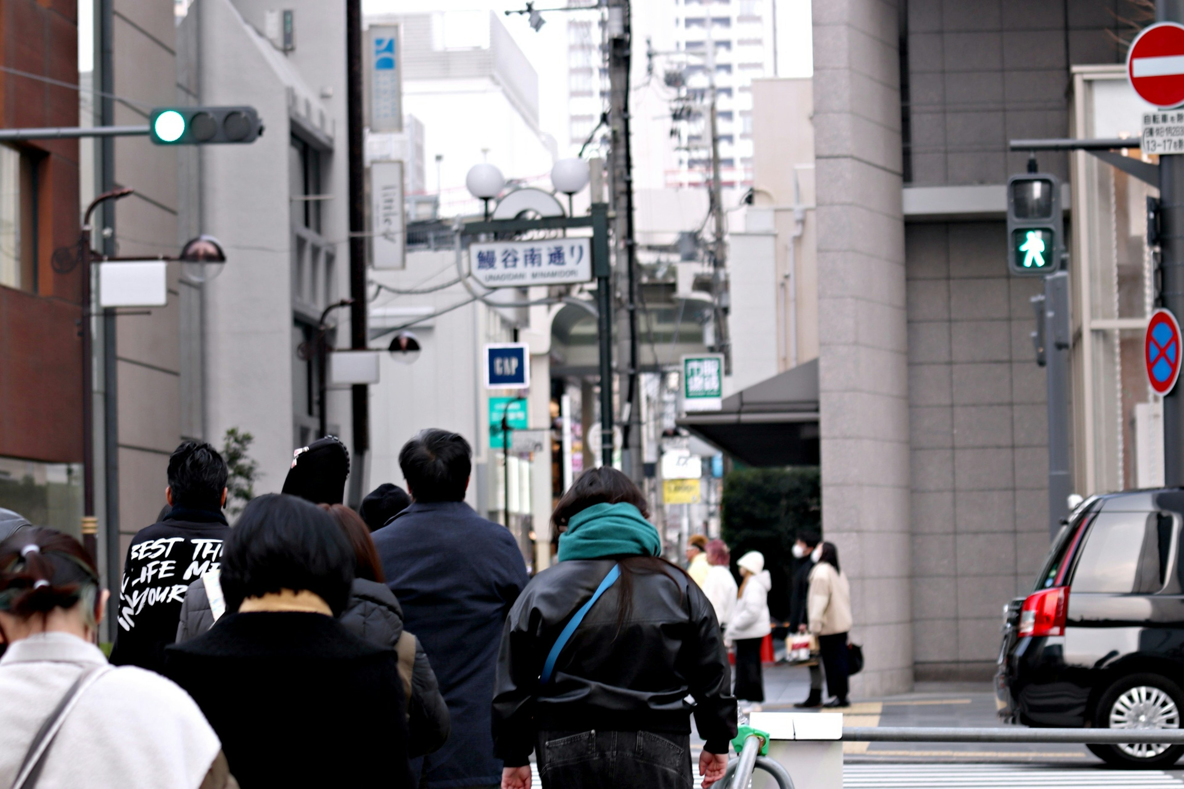 都市の街角で信号を待つ人々の行列