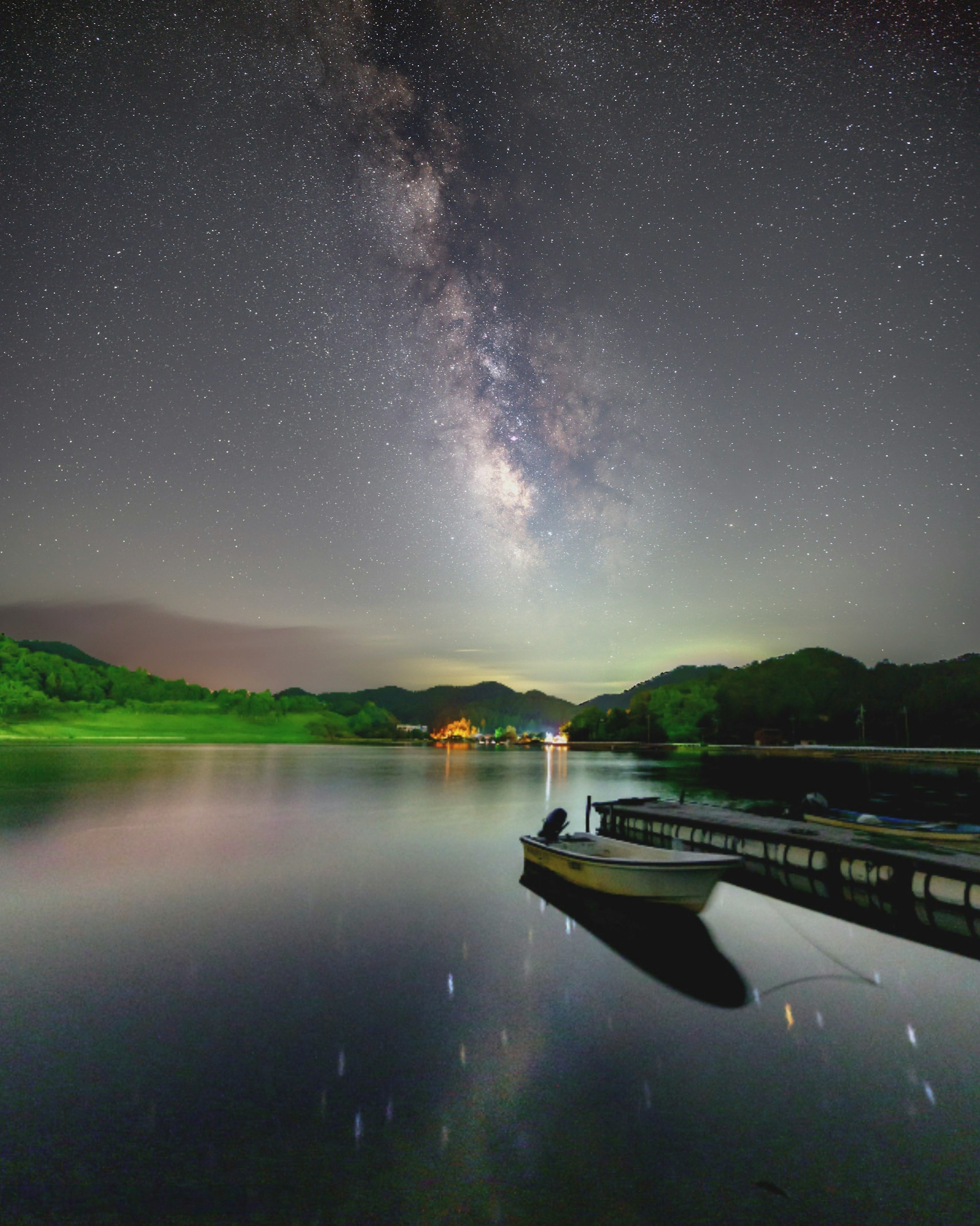 静かな湖の上に広がる満点の星空と天の川の美しい景色