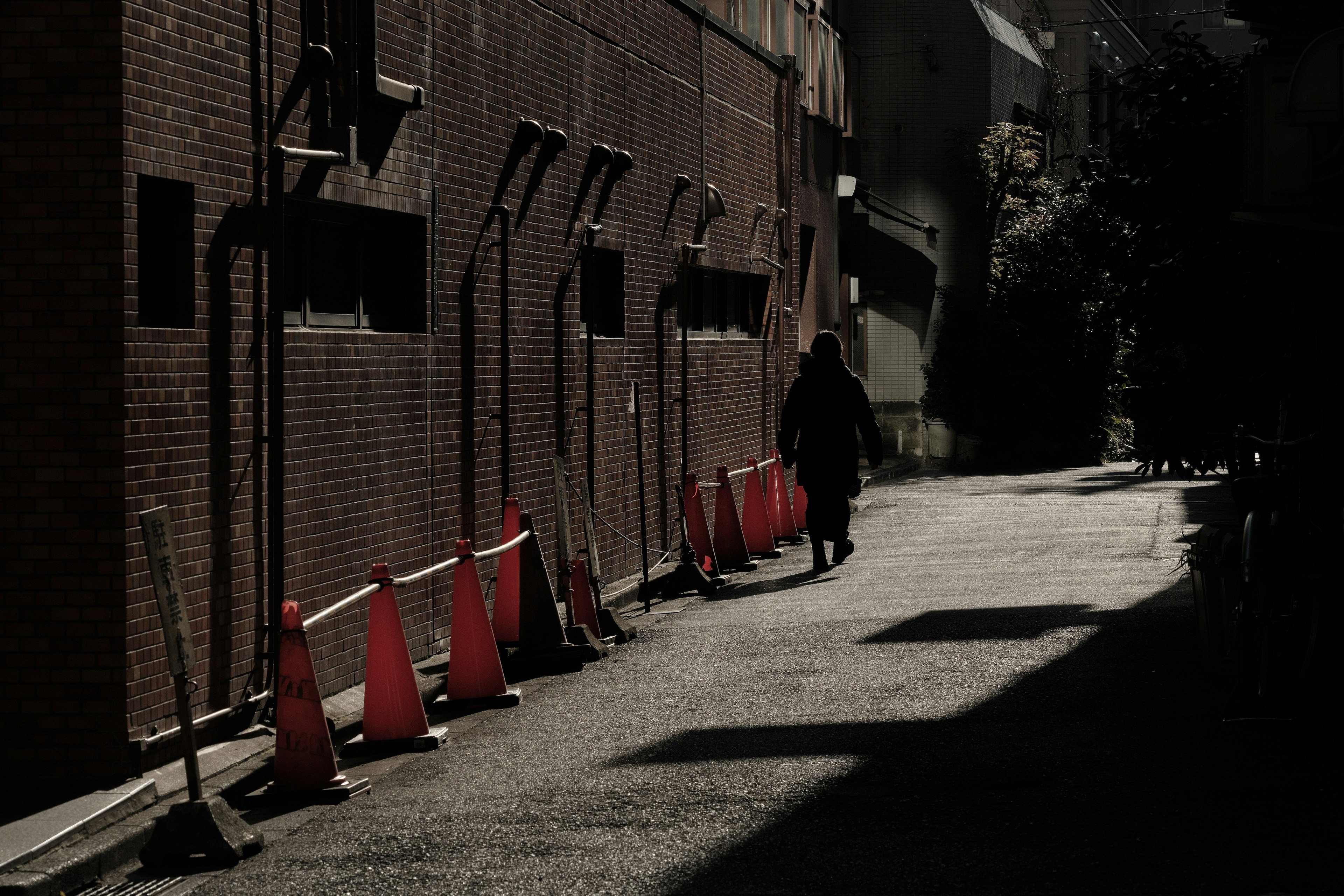 Eine schattige Gasse mit roten Kegeln und einer Silhouette