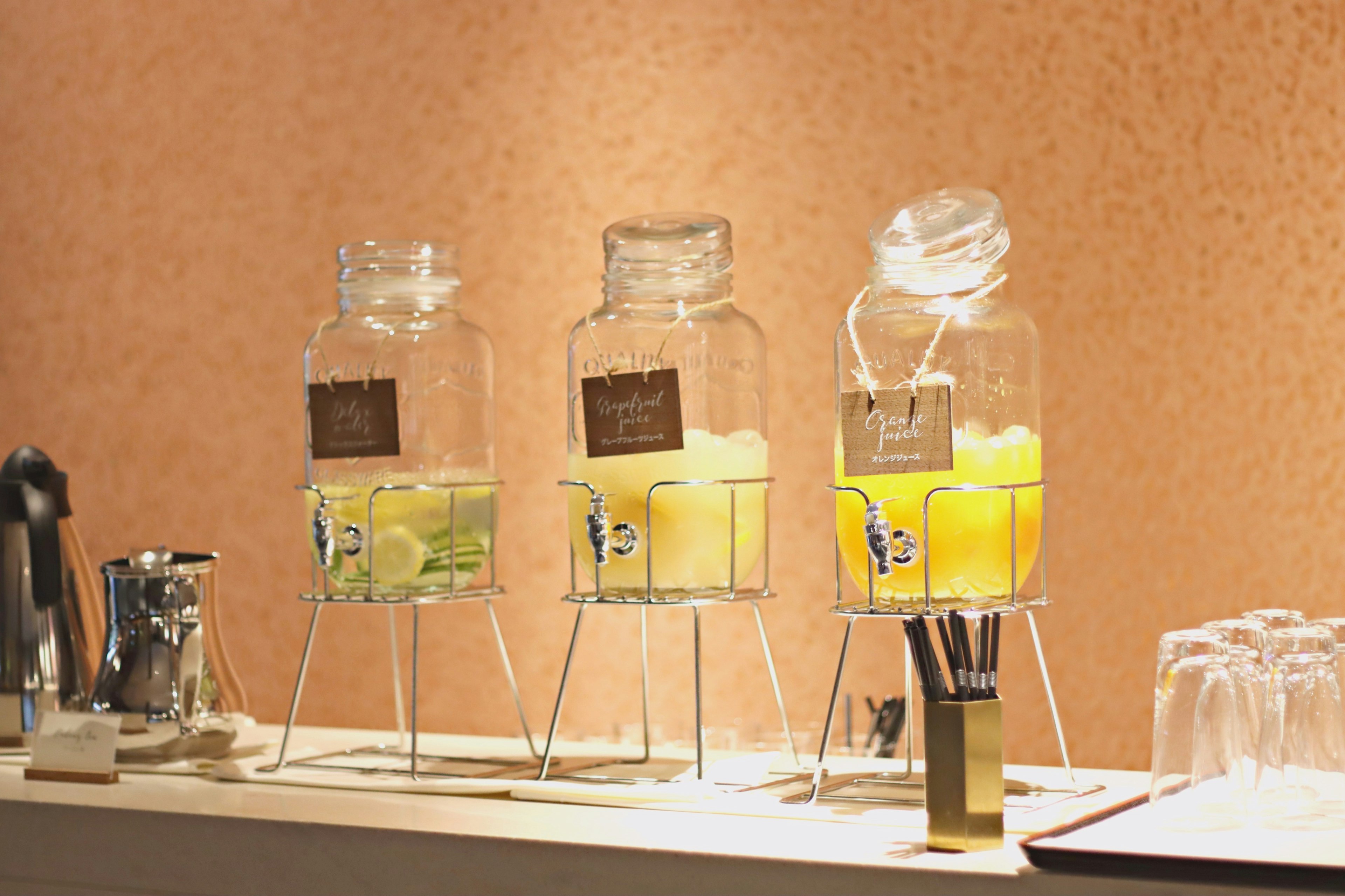 Set of transparent beverage dispensers containing lemonade and tea