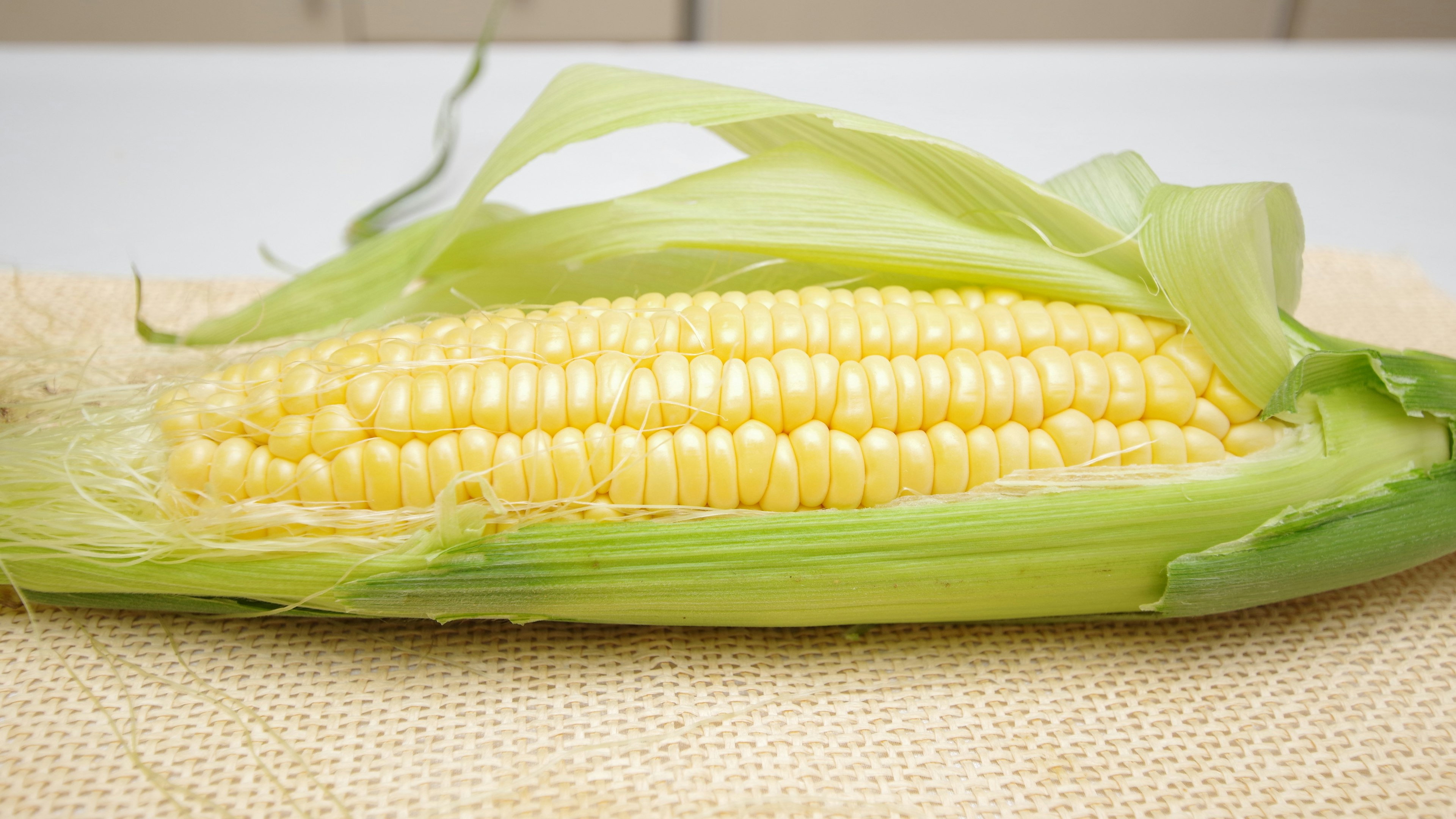 Jagung segar yang sebagian dikupas dengan biji kuning terlihat